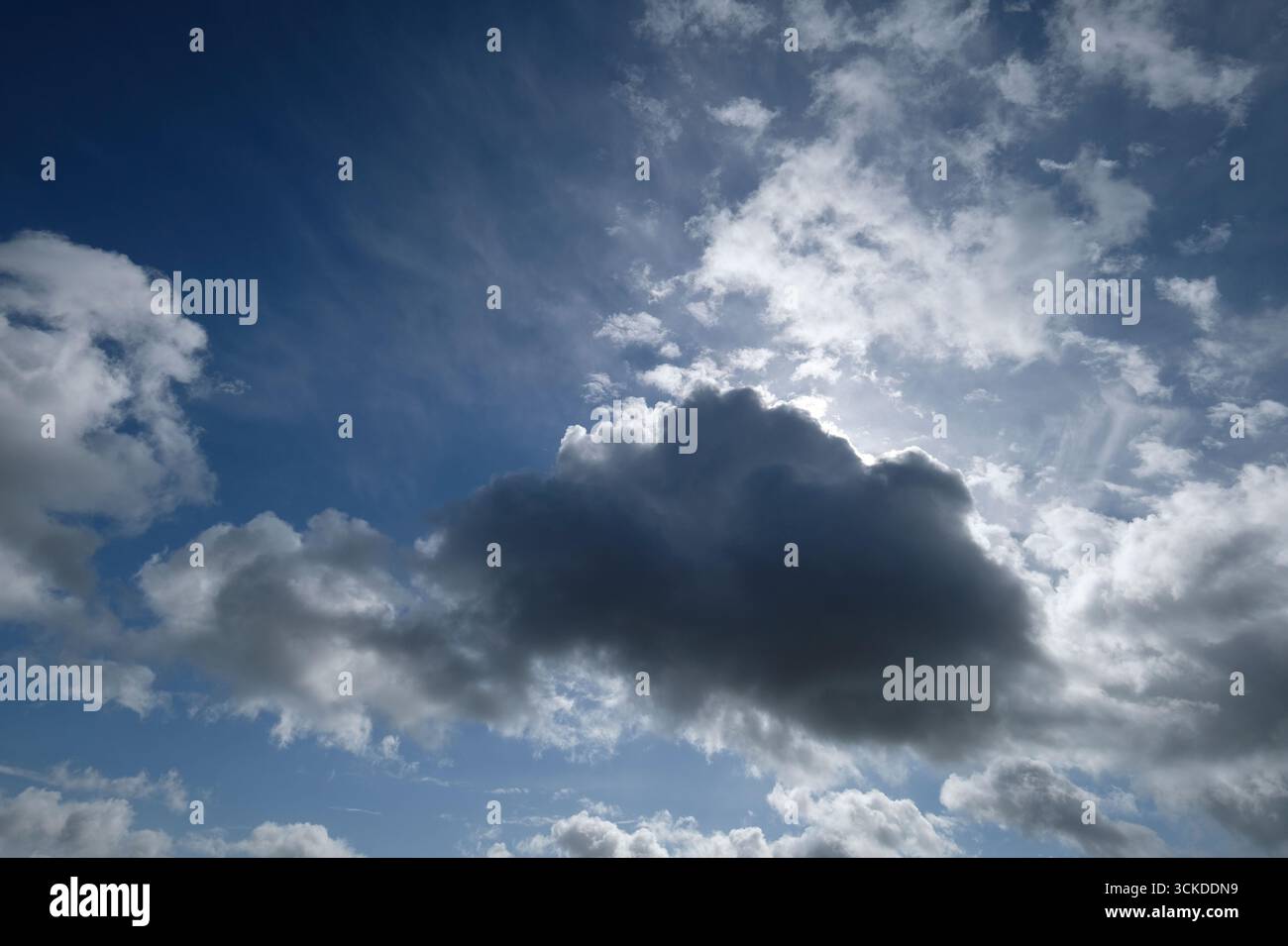 soleil brillant derrière les nuages sur fond de ciel bleu Banque D'Images