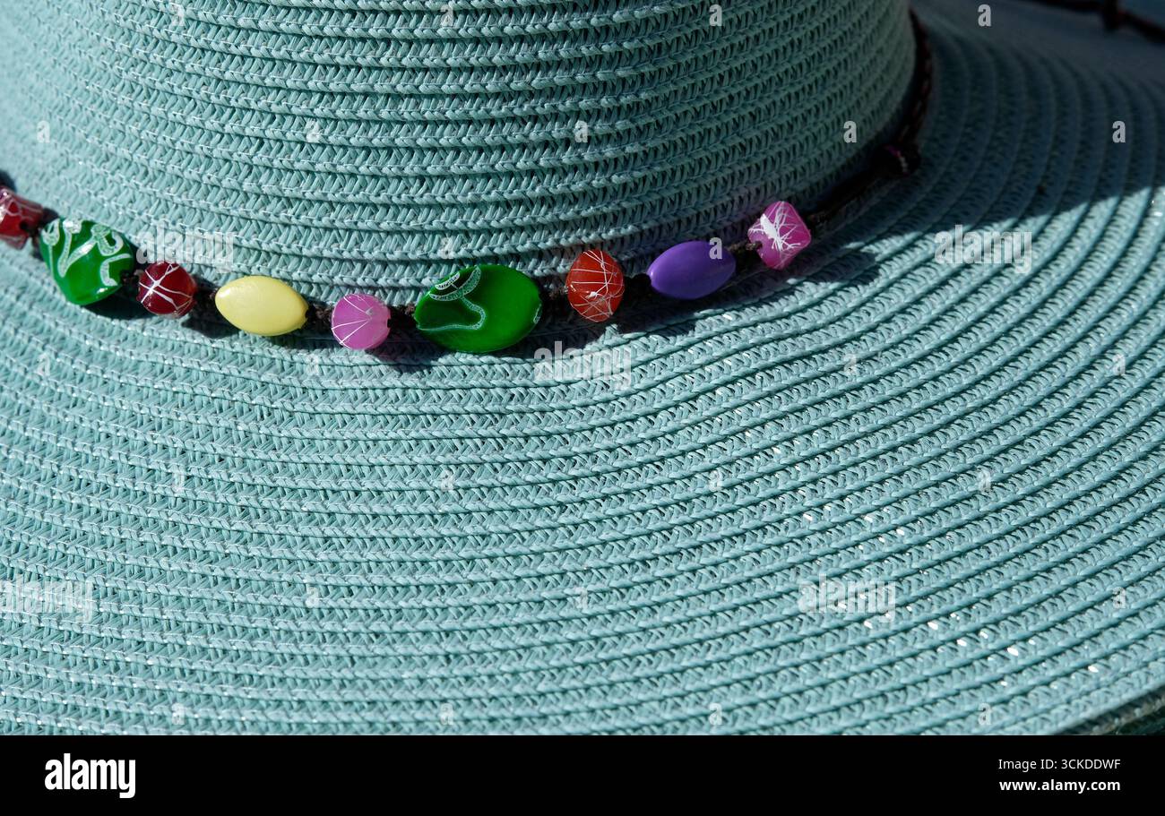 perles colorées autour d'un chapeau de soleil bleu Banque D'Images