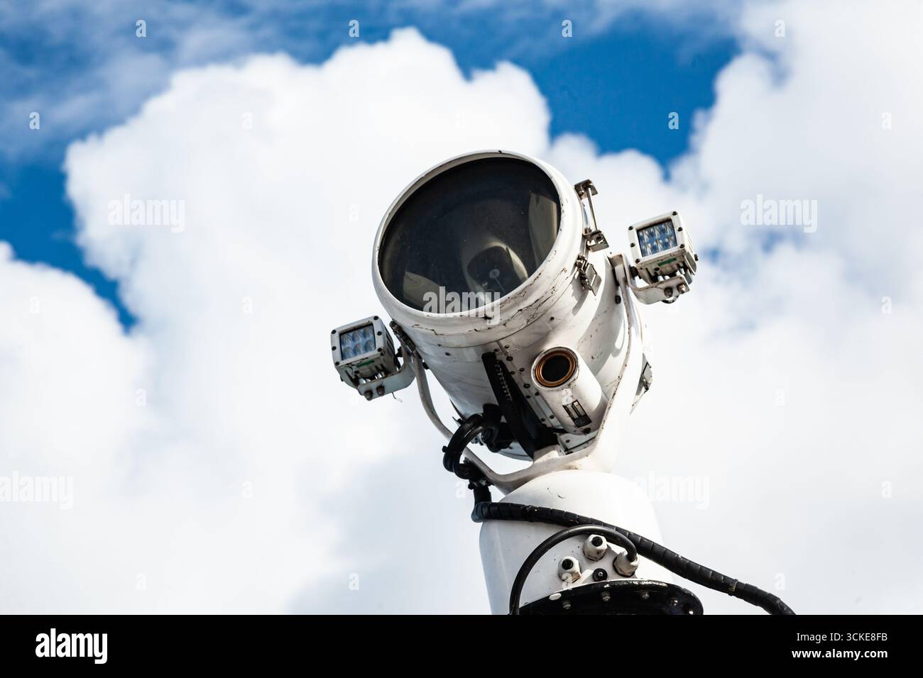 Projecteur industriel en acier monté sur un poteau haut contre un ciel bleu clair, gros plan Banque D'Images