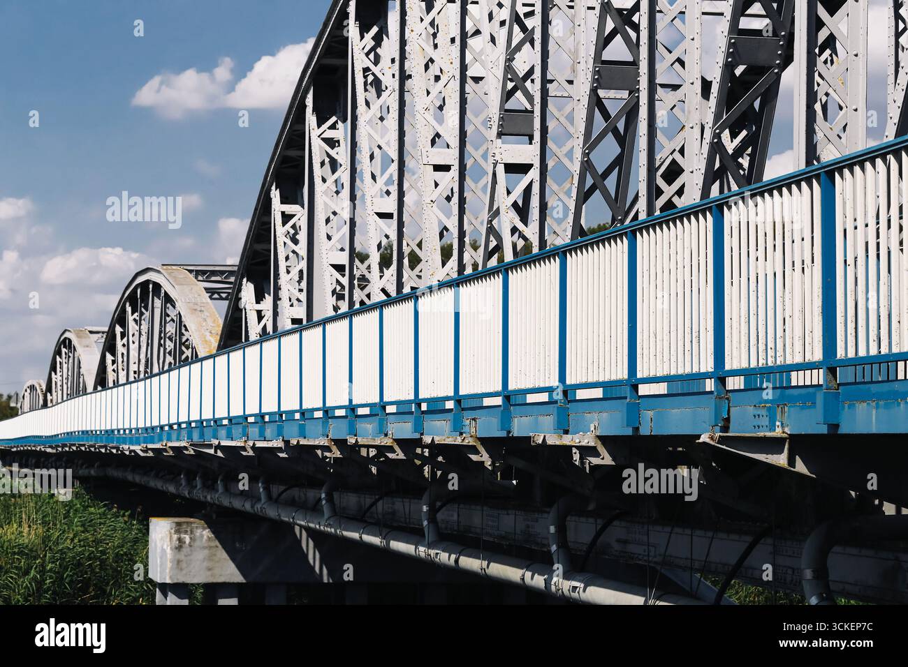 Vue en perspective d'un pont ferroviaire en acier. Structure bleue et blanche au-dessus de la rivière. Elément de construction d'architecture industrielle. Concept de transport. Banque D'Images