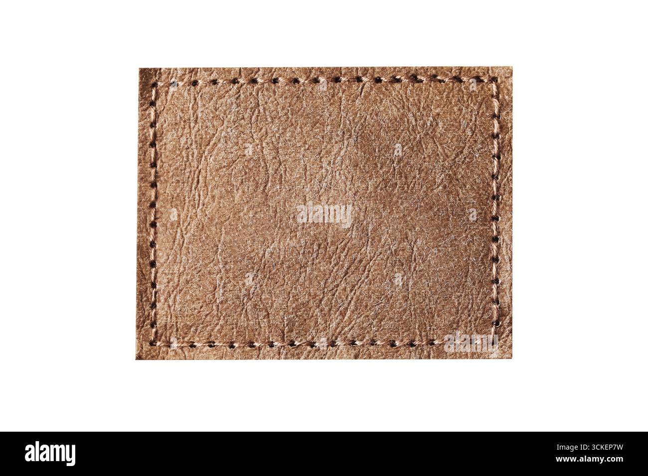 Patch en cuir marron avec détail couture. Gros plan sur l'étiquette rectangulaire vierge. Elément accessoire de création de mode. Décoration textile pour la marque de vêtements. Banque D'Images