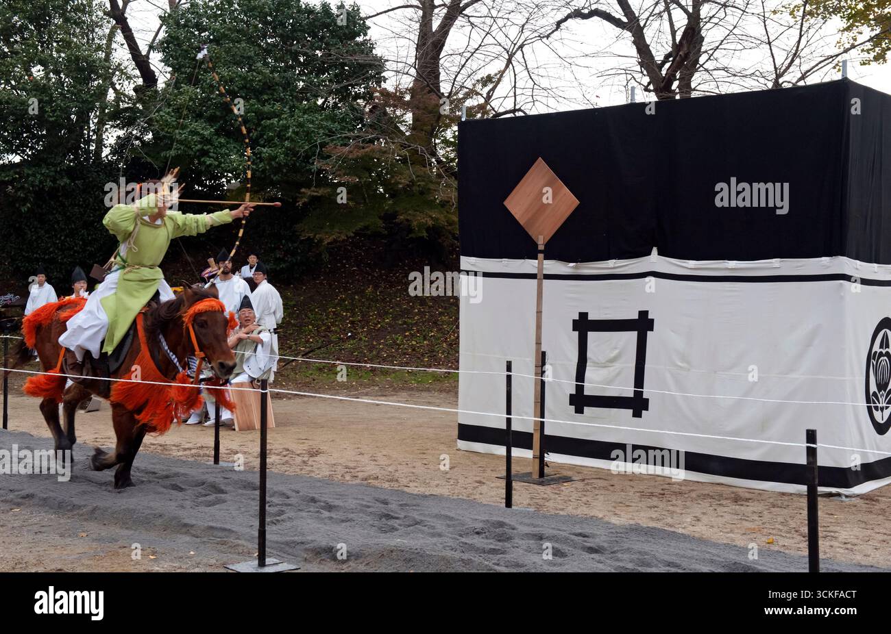 Des archers japonais sur des flèches à cheval tirant sur une cible en bois lors d'un tir à l'arc monté appelé yabusame (流鏑馬 ?) à Hikone, Shiga, Japon. Banque D'Images