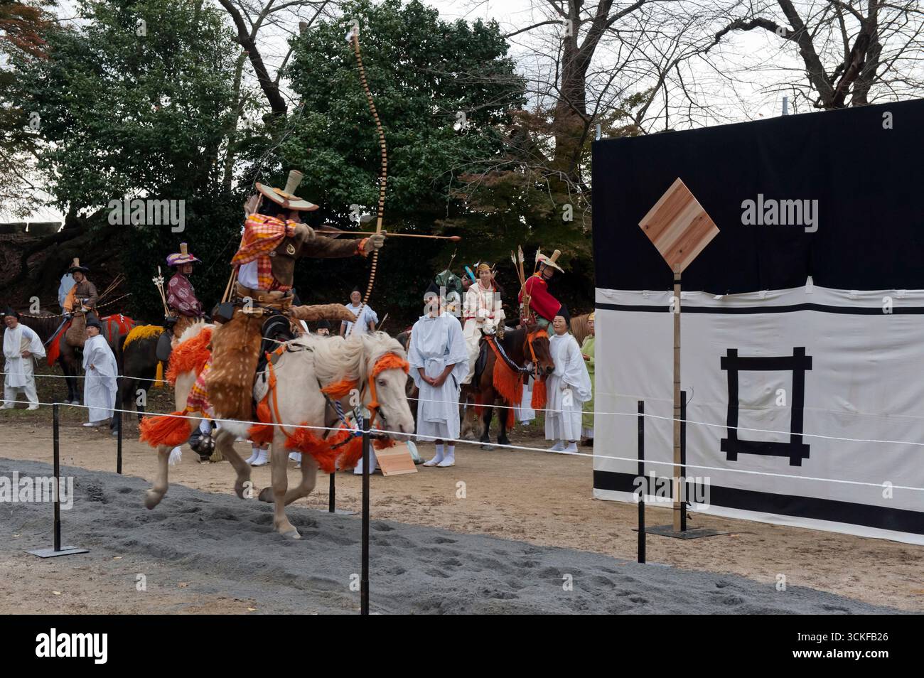 Des archers japonais sur des flèches à cheval tirant sur une cible en bois lors d'un tir à l'arc monté appelé yabusame (流鏑馬 ?) à Hikone, Shiga, Japon. Banque D'Images