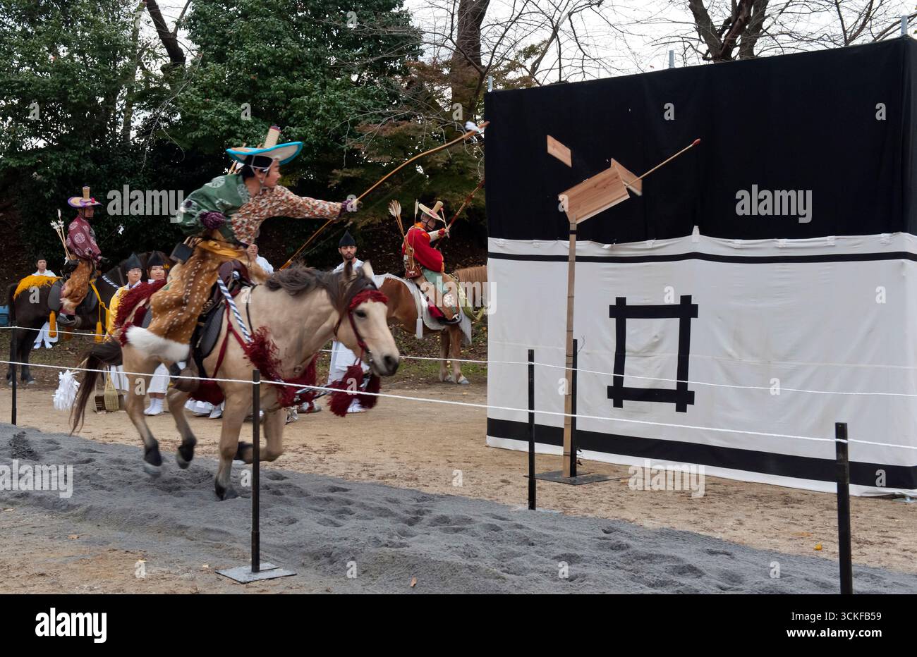 Des archers japonais sur des flèches à cheval tirant sur une cible en bois lors d'un tir à l'arc monté appelé yabusame (流鏑馬 ?) à Hikone, Shiga, Japon. Banque D'Images