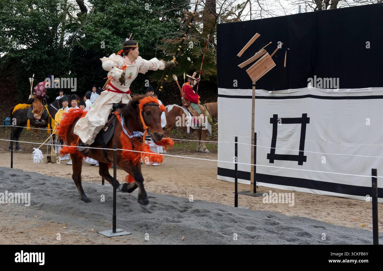 Des archers japonais sur des flèches à cheval tirant sur une cible en bois lors d'un tir à l'arc monté appelé yabusame (流鏑馬 ?) à Hikone, Shiga, Japon. Banque D'Images