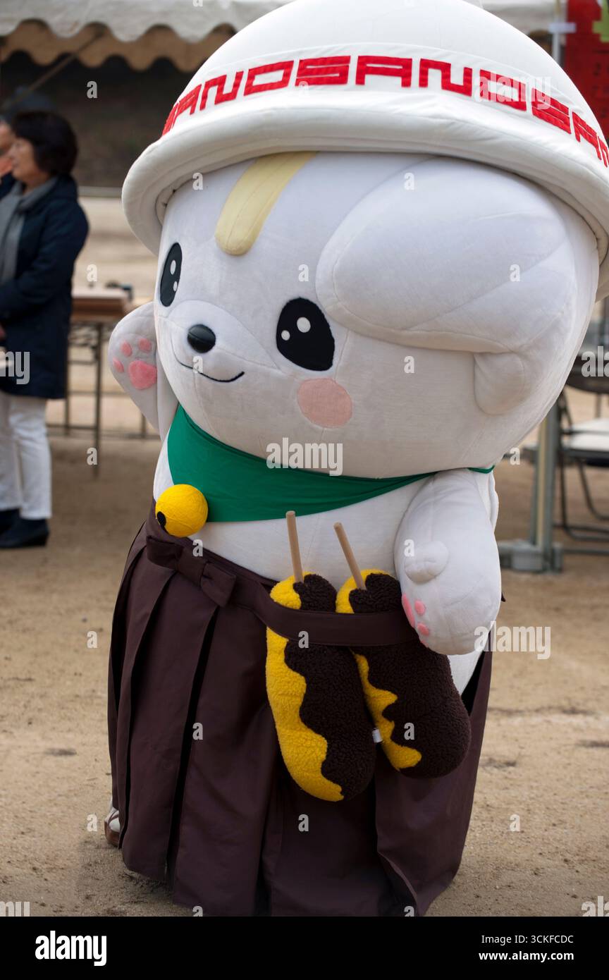 Mascotte japonaise yuru-kyara personnages de culture populaire Sanomaru (bol à soupe sur la tête et tenant le kushikatsu) lors d'un événement à Hikone, Shiga, Japon. Banque D'Images