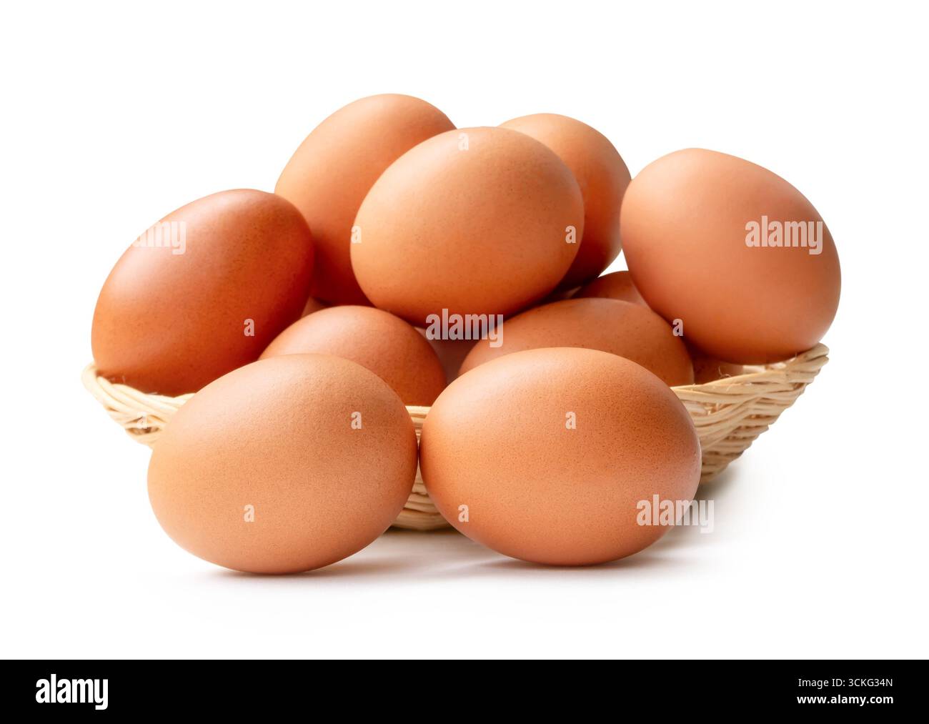 Beaucoup d'œufs de poule bruns dans la pile dans le panier en osier sont isolés sur fond blanc avec chemin de découpage. Banque D'Images