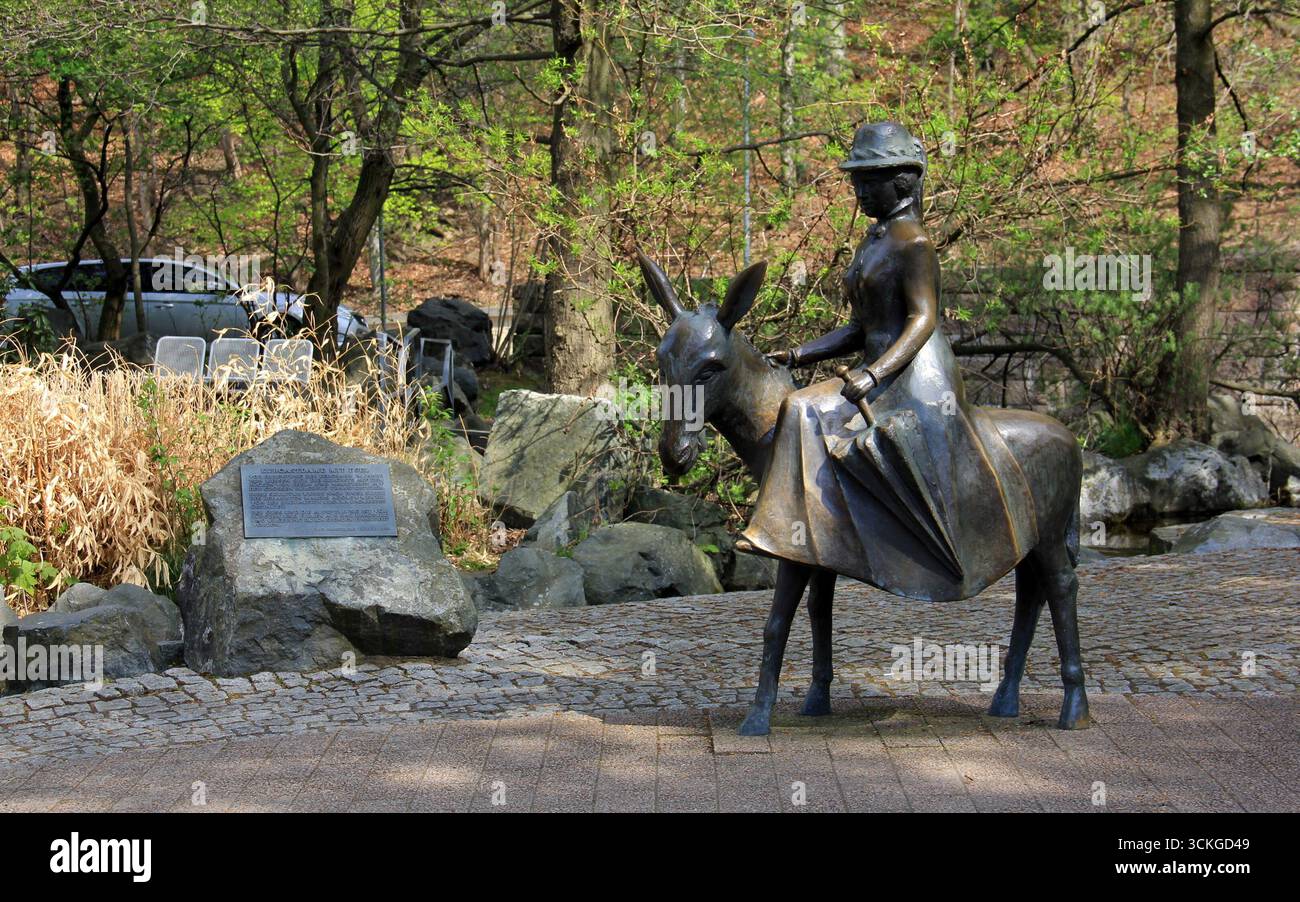 Spa Guest Lady sur un âne, sculpture de 1989, par Ursula Bacmeister, installée à Kurpark, Bad Harzburg, Allemagne Banque D'Images Spa Guest Lady sur un âne, sculpture de 1989, par Ursula Bacmeister, installée à Kurpark, Bad Harzburg, Allemagne Banque D'Images