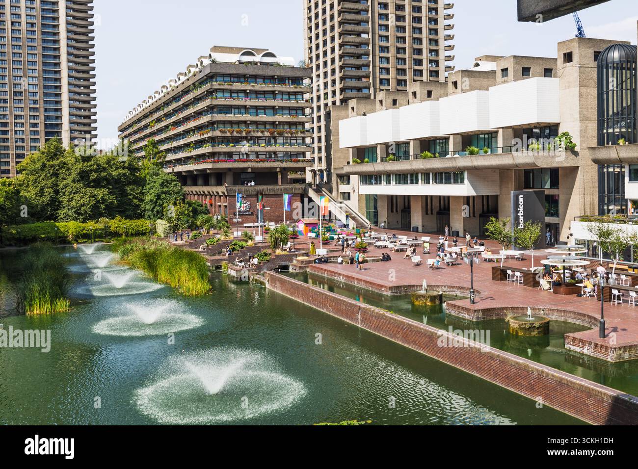 Barbican Centre au bord du lac avec fontaines et tours brutalistes. Londres, Royaume-Uni, 17 août 2024 Banque D'Images