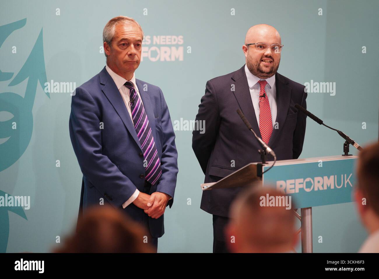 Le leader réformiste britannique Nigel Farage regarde Llyr Powell (à droite), qui a été choisi comme candidat du parti pour la prochaine élection partielle de Caerphilly Senedd, prendre la parole lors d'une conférence de presse à Caerphilly. L’élection partielle doit avoir lieu le 23 octobre pour élire le nouveau membre du Senedd à la suite du décès de Hbean David le 12 août. Date de la photo : vendredi 12 septembre 2025. Banque D'Images Le leader réformiste britannique Nigel Farage regarde Llyr Powell (à droite), qui a été choisi comme candidat du parti pour la prochaine élection partielle de Caerphilly Senedd, prendre la parole lors d'une conférence de presse à Caerphilly. L’élection partielle doit avoir lieu le 23 octobre pour élire le nouveau membre du Senedd à la suite du décès de Hbean David le 12 août. Date de la photo : vendredi 12 septembre 2025. Banque D'Images