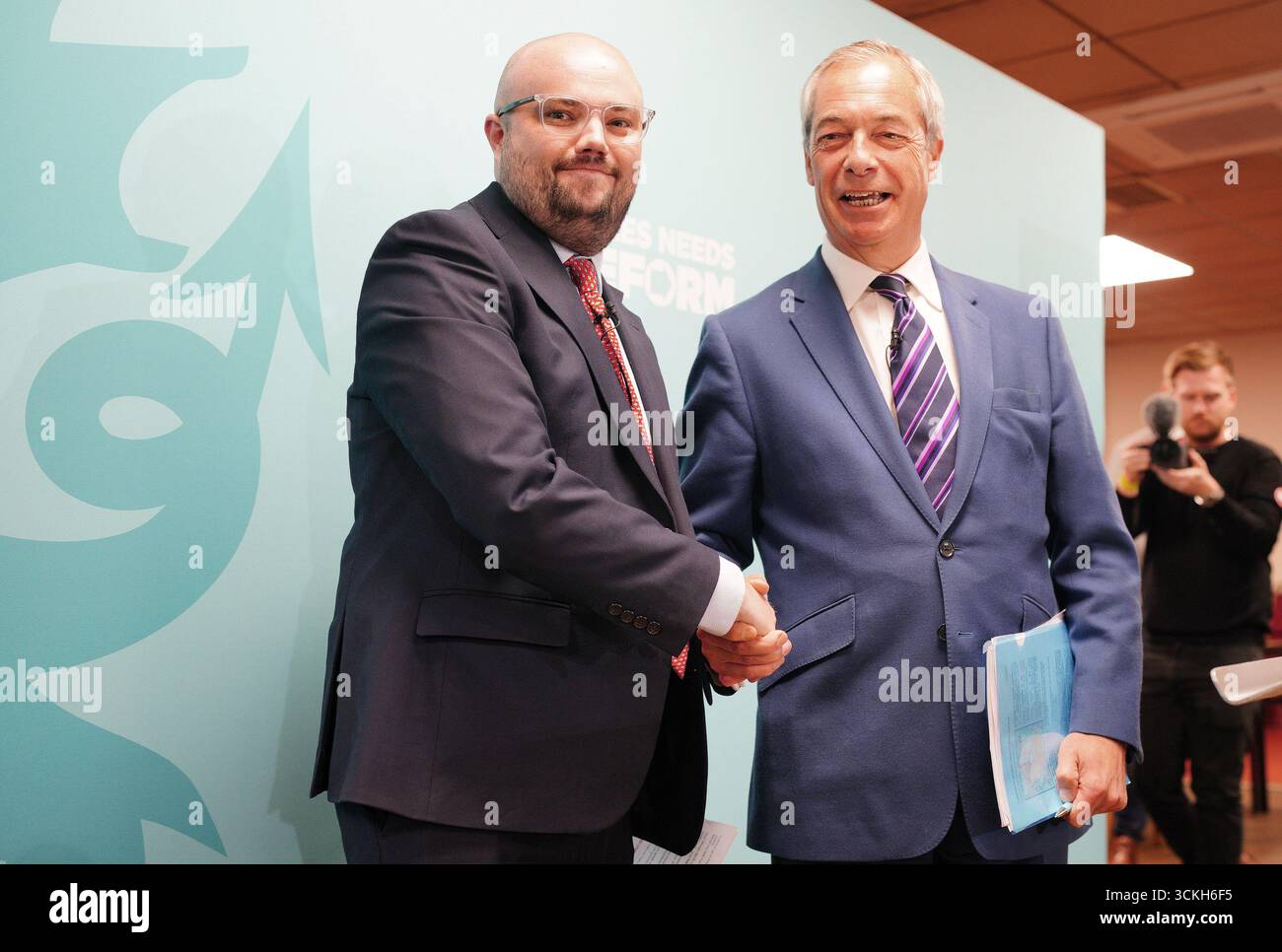 Le leader réformiste britannique Nigel Farage serre la main de Llyr Powell (à gauche), qui a été choisi comme candidat du parti pour la prochaine élection partielle de Caerphilly Senedd, lors d'une conférence de presse à Caerphilly. L’élection partielle doit avoir lieu le 23 octobre pour élire le nouveau membre du Senedd à la suite du décès de Hbean David le 12 août. Date de la photo : vendredi 12 septembre 2025. Banque D'Images Le leader réformiste britannique Nigel Farage serre la main de Llyr Powell (à gauche), qui a été choisi comme candidat du parti pour la prochaine élection partielle de Caerphilly Senedd, lors d'une conférence de presse à Caerphilly. L’élection partielle doit avoir lieu le 23 octobre pour élire le nouveau membre du Senedd à la suite du décès de Hbean David le 12 août. Date de la photo : vendredi 12 septembre 2025. Banque D'Images