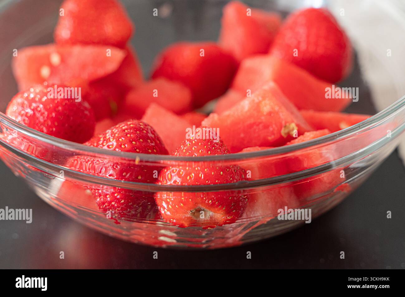 Un mélange coloré de fraises fraîches et de pastèque juteuse, parfait pour les collations estivales ou les desserts sains Banque D'Images