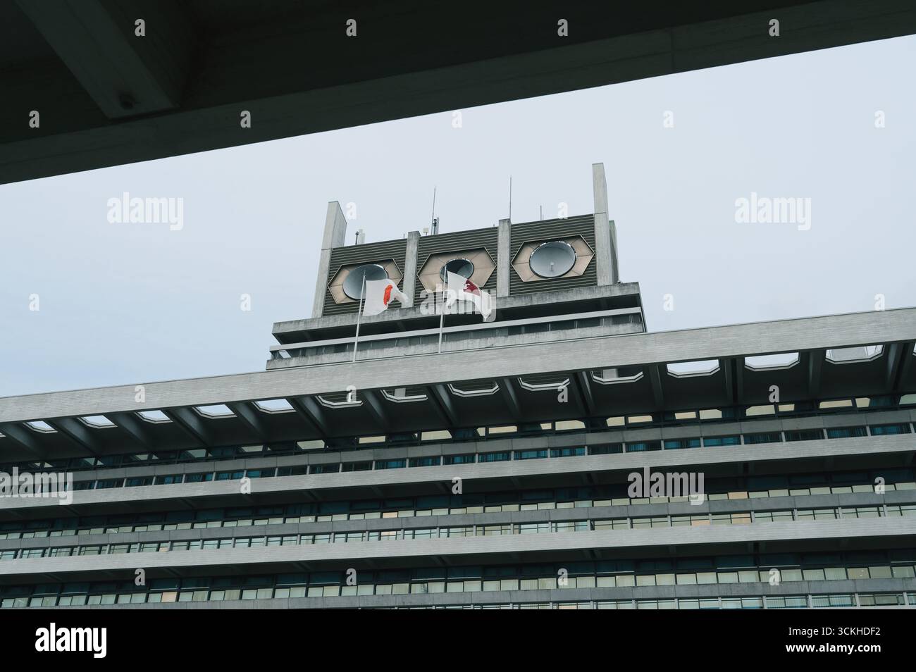 L'imposante façade de l'hôtel de ville de Nara s'élève dans des lignes de béton, deux drapeaux du Japon flottant dans la brise Banque D'Images