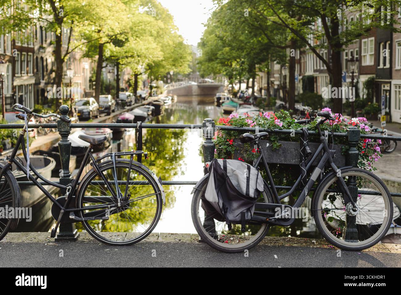 Vélos sur le pont du canal avec des fleurs et des maisons historiques Banque D'Images