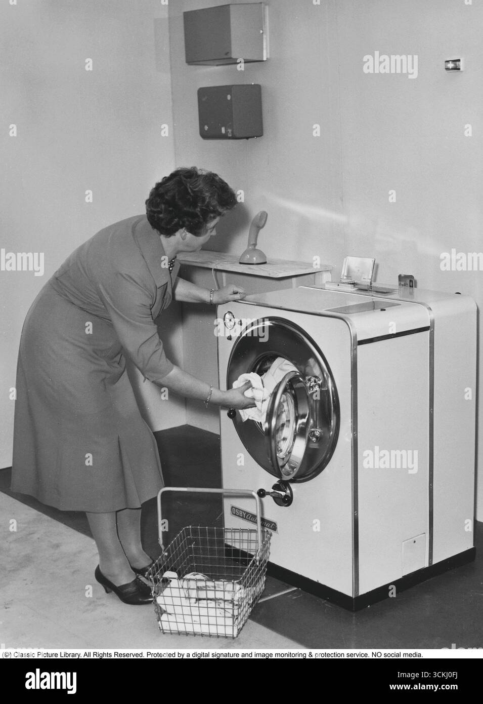 Le Teletvätt, introduit dans les années 1950 par la société suédoise Electrolux, était un premier lave-linge automatisé avec une fonction unique de réservation par téléphone. Vu debout sur le banc ; l'Ericofon : l'emblématique téléphone monobloc en plastique. Ce design suédois innovant, créé par The Ericsson Company et lancé en 1956, combine le cadran et le combiné en une seule unité. Pour passer un appel, vous avez simplement décroché et composé ; pour terminer, vous l'avez décroché. Réputé pour son style élégant et son influence sur les futurs modèles de téléphones, l'Ericofon est salué comme l'un des desi industriels les plus importants du XXe siècle Banque D'Images