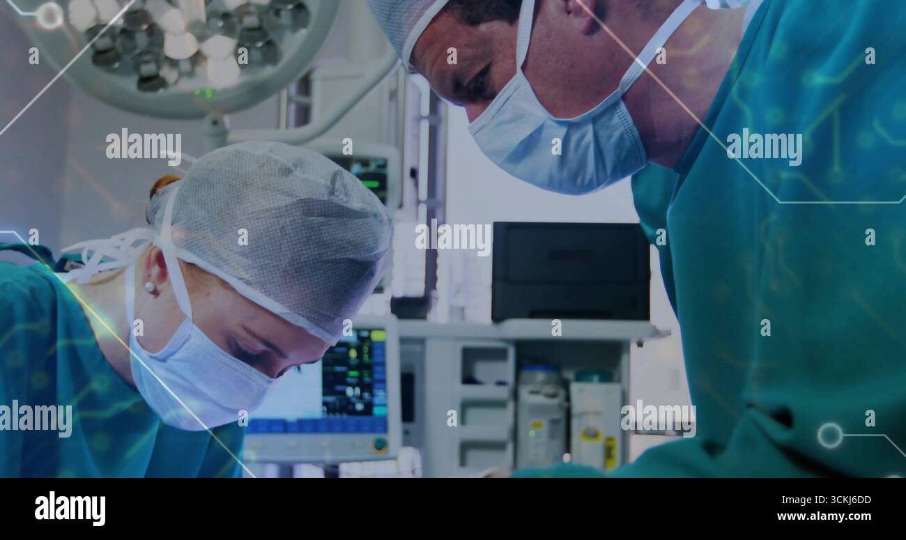 Chirurgiens penchants dans les gommages pratiquant une intervention chirurgicale au BLOC OPÉRATOIRE, avec plafonnier et moniteur vital Banque D'Images