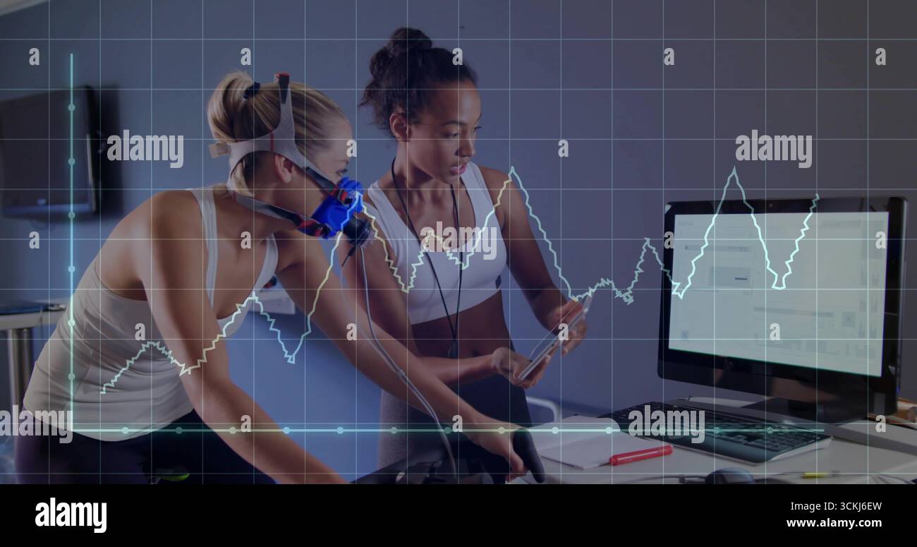 Athlète cycliste portant un masque respiratoire sur un vélo stationnaire en laboratoire, avec un entraîneur tenant la tablette Banque D'Images