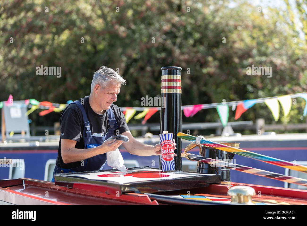 Dudley, West Midlands, Royaume-Uni. 12 septembre 2025. Steve Whitehouse, batelier du canal, met le dernier vernis sur son bateau étroit « Hudson » alors que des dizaines de bateaux se rassemblent pour le Black Country Boating Festival à Dudley le week-end prochain. Le bateau de M. Whitehouse est un navire relativement récent datant de 2010, mais il est propulsé par un moteur diesel 1935. Le festival se déroule à la jonction du canal de Bumble Hole au cœur du Black Country depuis le milieu des années 1980 Crédit : Peter Lopeman/Alamy Live News Banque D'Images