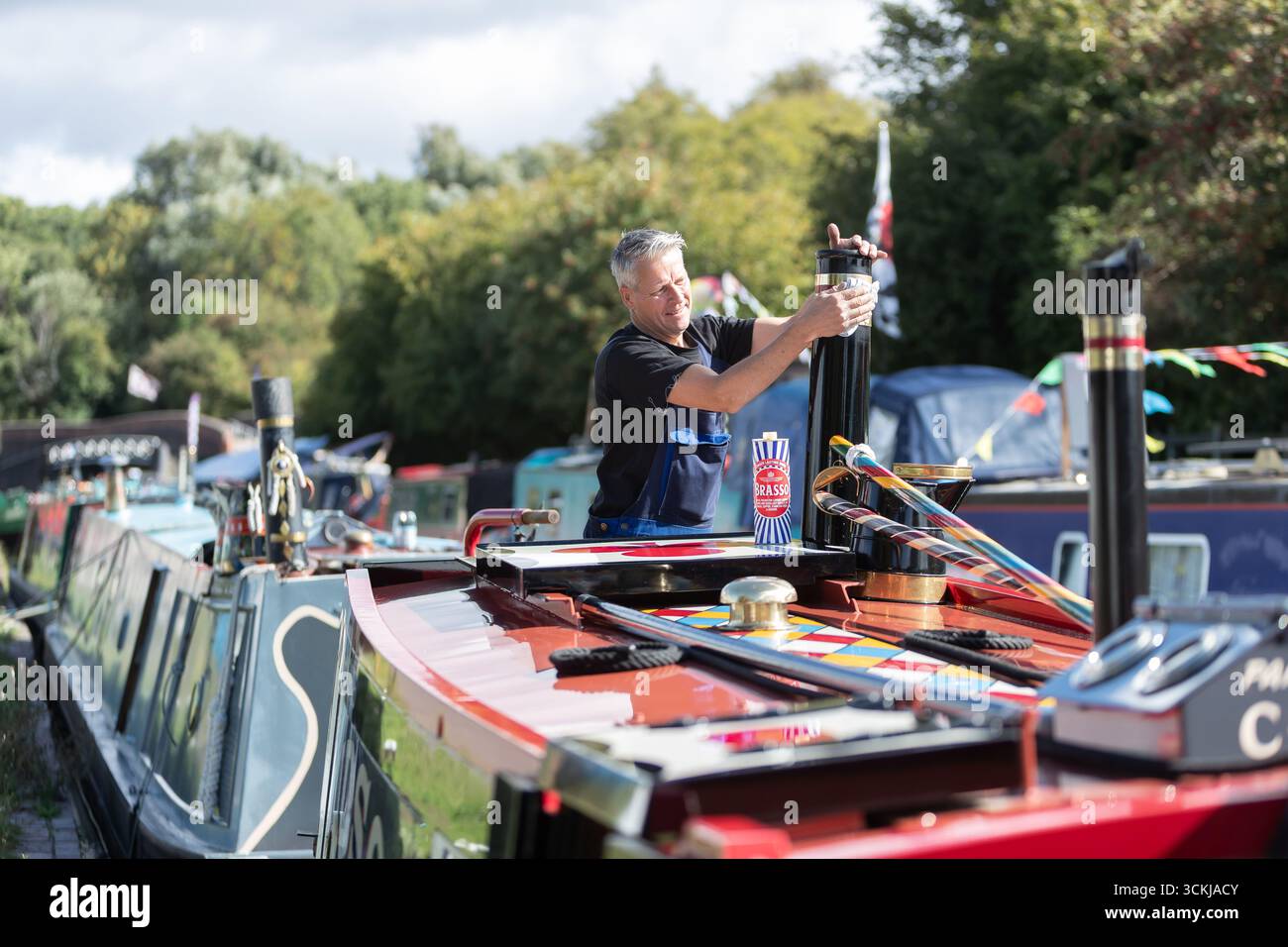 Dudley, West Midlands, Royaume-Uni. 12 septembre 2025. Steve Whitehouse, batelier du canal, met le dernier vernis sur son bateau étroit « Hudson » alors que des dizaines de bateaux se rassemblent pour le Black Country Boating Festival à Dudley le week-end prochain. Le bateau de M. Whitehouse est un navire relativement récent datant de 2010, mais il est propulsé par un moteur diesel 1935. Le festival se déroule à la jonction du canal de Bumble Hole au cœur du Black Country depuis le milieu des années 1980 Crédit : Peter Lopeman/Alamy Live News Banque D'Images