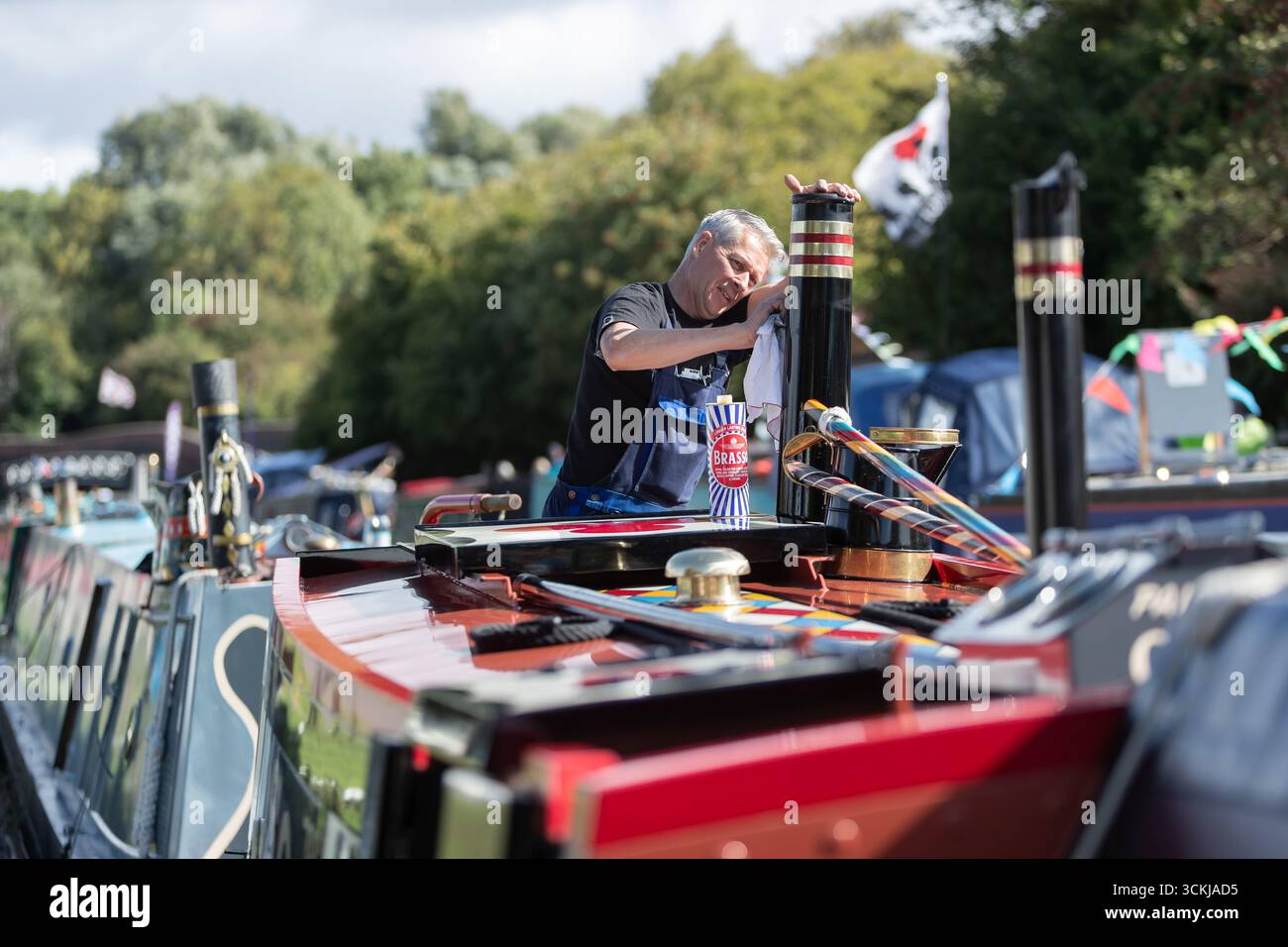 Dudley, West Midlands, Royaume-Uni. 12 septembre 2025. Steve Whitehouse, batelier du canal, met le dernier vernis sur son bateau étroit « Hudson » alors que des dizaines de bateaux se rassemblent pour le Black Country Boating Festival à Dudley le week-end prochain. Le bateau de M. Whitehouse est un navire relativement récent datant de 2010, mais il est propulsé par un moteur diesel 1935. Le festival se déroule à la jonction du canal de Bumble Hole au cœur du Black Country depuis le milieu des années 1980 Crédit : Peter Lopeman/Alamy Live News Banque D'Images