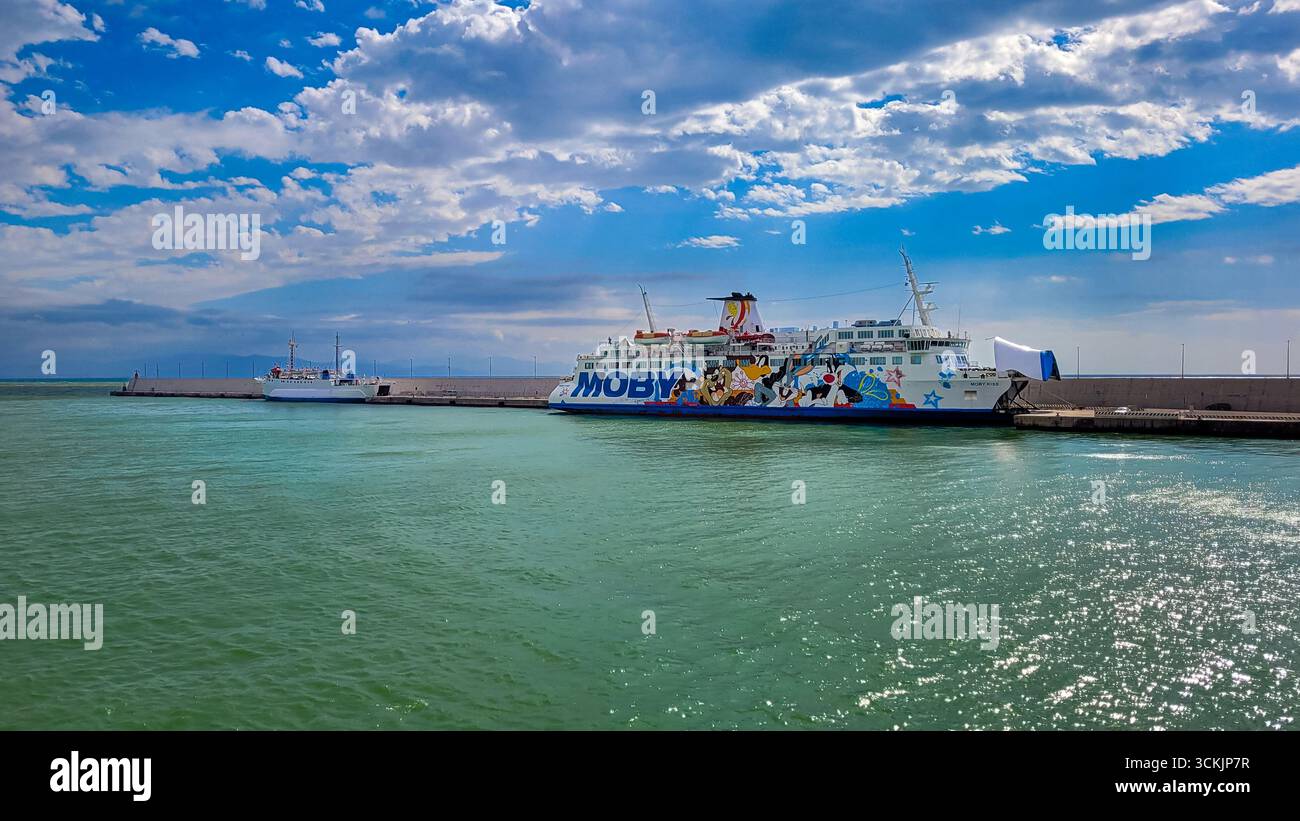 Un ferry Moby Lines dans le port de Toscane. En arrière-plan - ciel bleu et nuages blancs, au premier plan brillante mer émeraude. 28 septembre 2024. L Banque D'Images