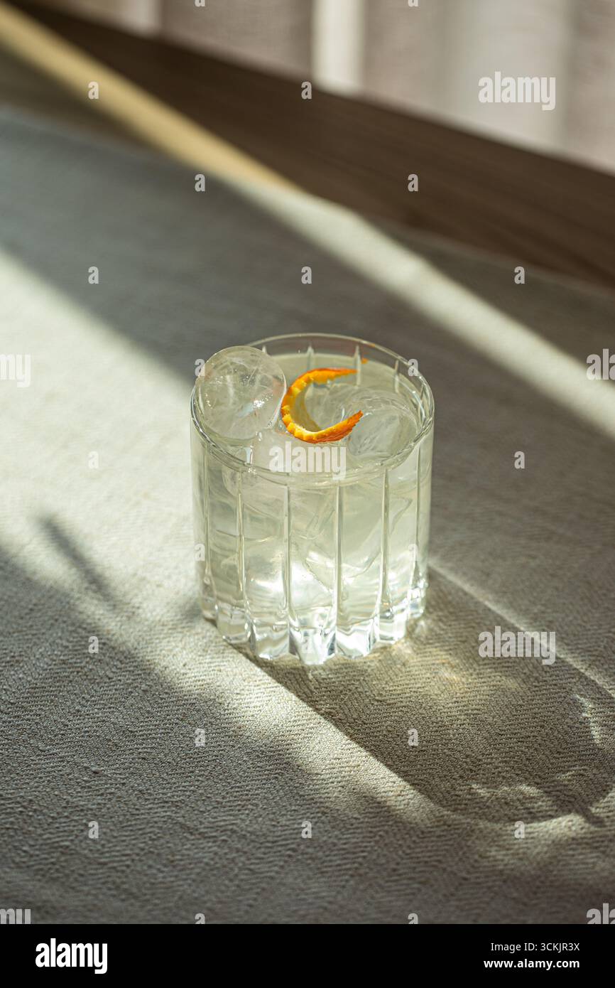 Gin et cocktail tonique avec glace dans un verre à facettes Banque D'Images