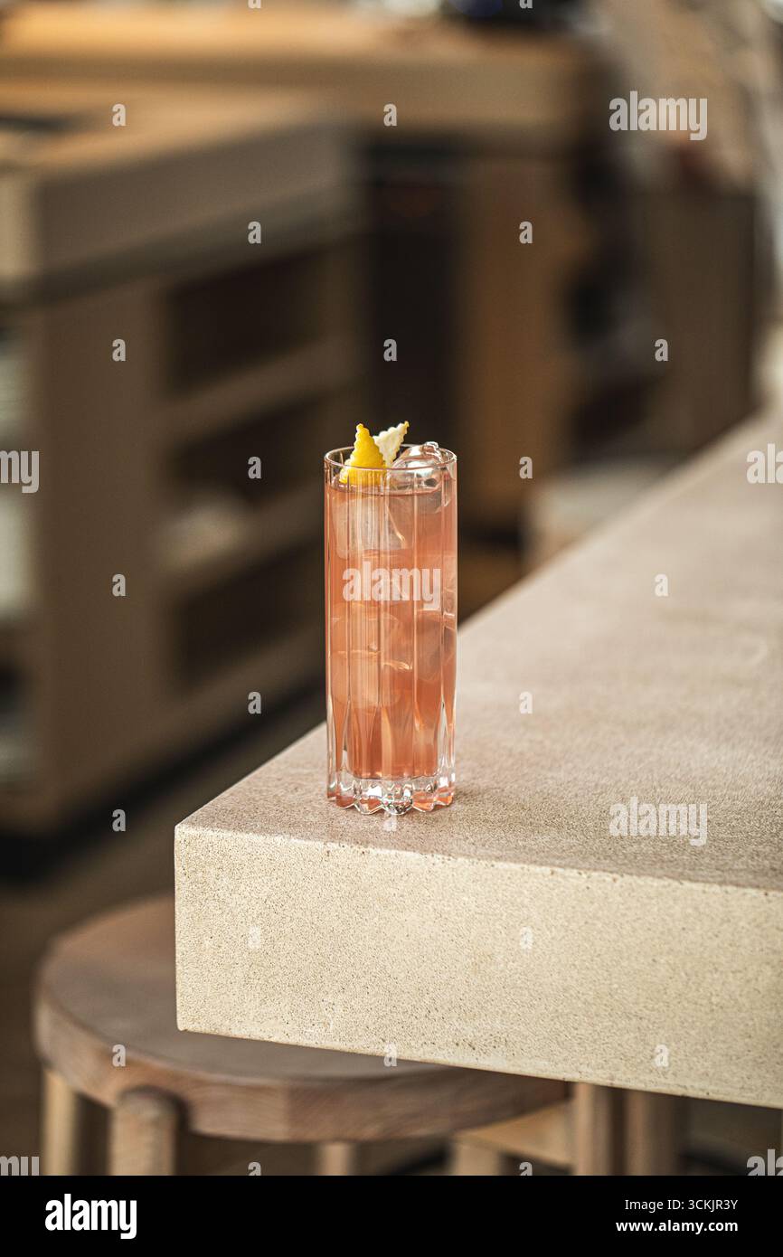 Cocktail rose dans un grand verre avec citron et glace Banque D'Images