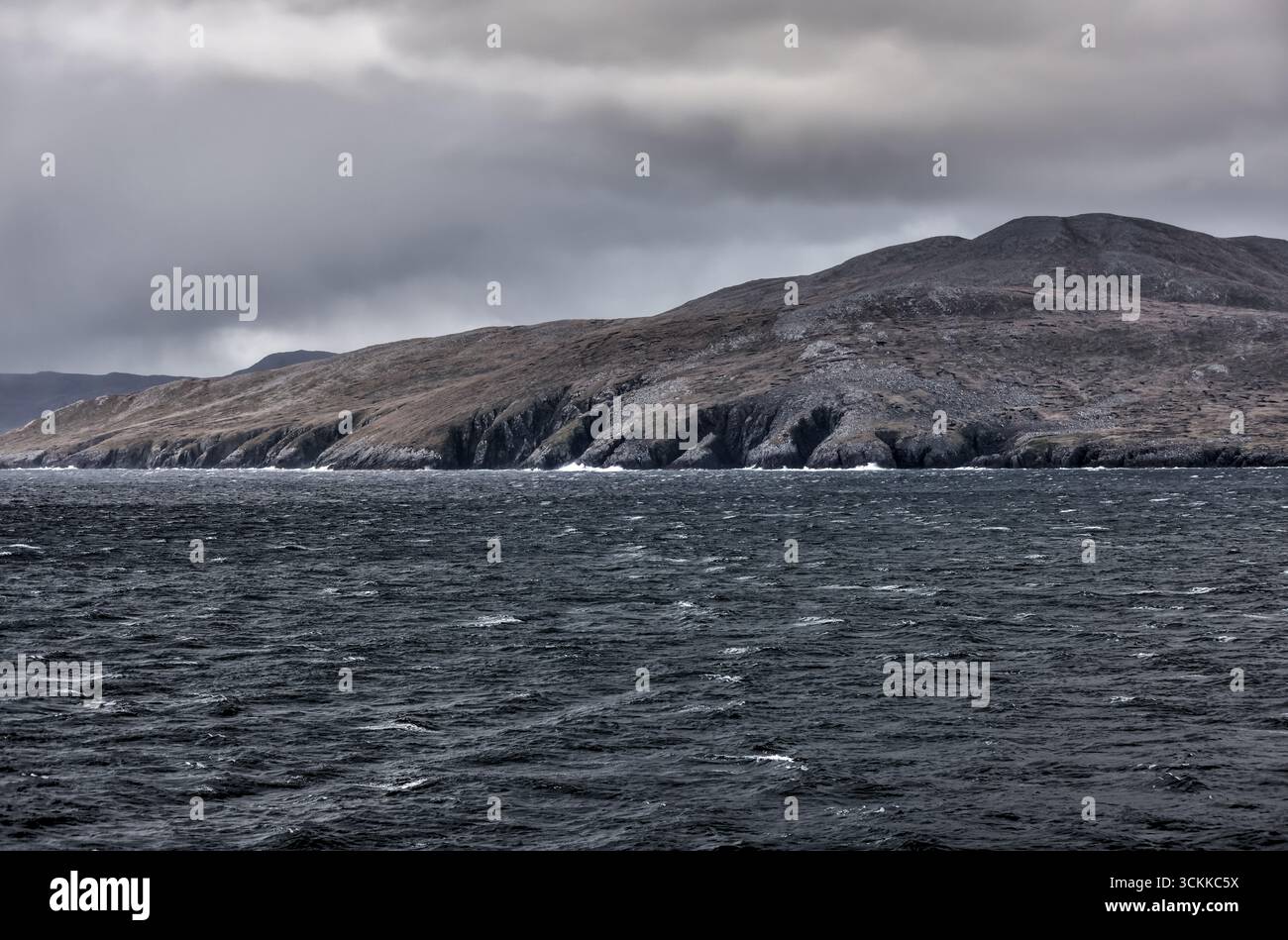 Cap Horn, Chili – 23 décembre 2022 : falaises escarpées du Cap Horn vues depuis un bateau de croisière traversant le passage de Drake sous un ciel spectaculaire Banque D'Images