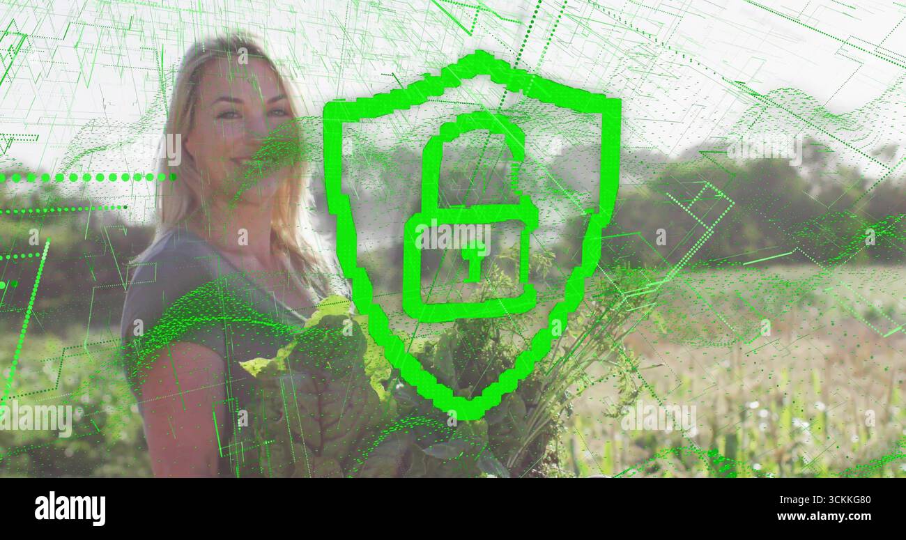 Femme adulte tenant de la laitue dans des terres agricoles ensoleillées avec des rangées de cultures, soulignant le thème de la sécurité numérique Banque D'Images