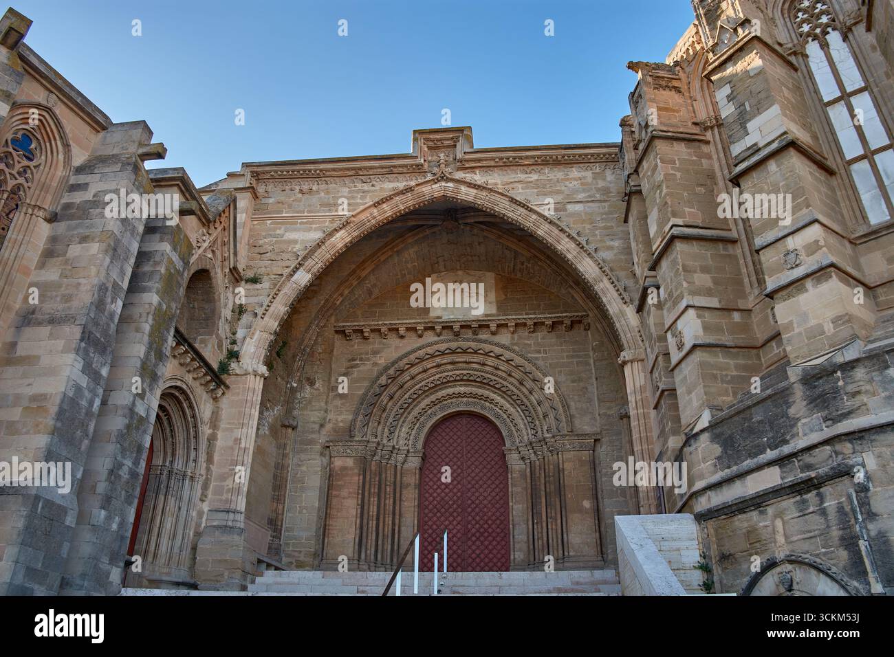 La porte Els Fillols de l'ancienne cathédrale de Lleida présente un arc gothique en pierre sculptée et une porte en bois rougeâtre. Son histoire Banque D'Images
