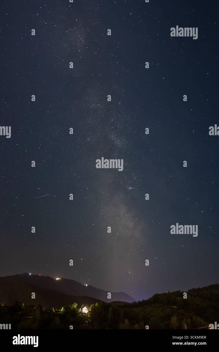 Paysage nocturne avec la voie lactée visible au-dessus des montagnes et de la forêt. Ciel étoilé avec d'innombrables étoiles brillantes et détails cosmiques avec grue de levage. Banque D'Images Paysage nocturne avec la voie lactée visible au-dessus des montagnes et de la forêt. Ciel étoilé avec d'innombrables étoiles brillantes et détails cosmiques avec grue de levage. Banque D'Images