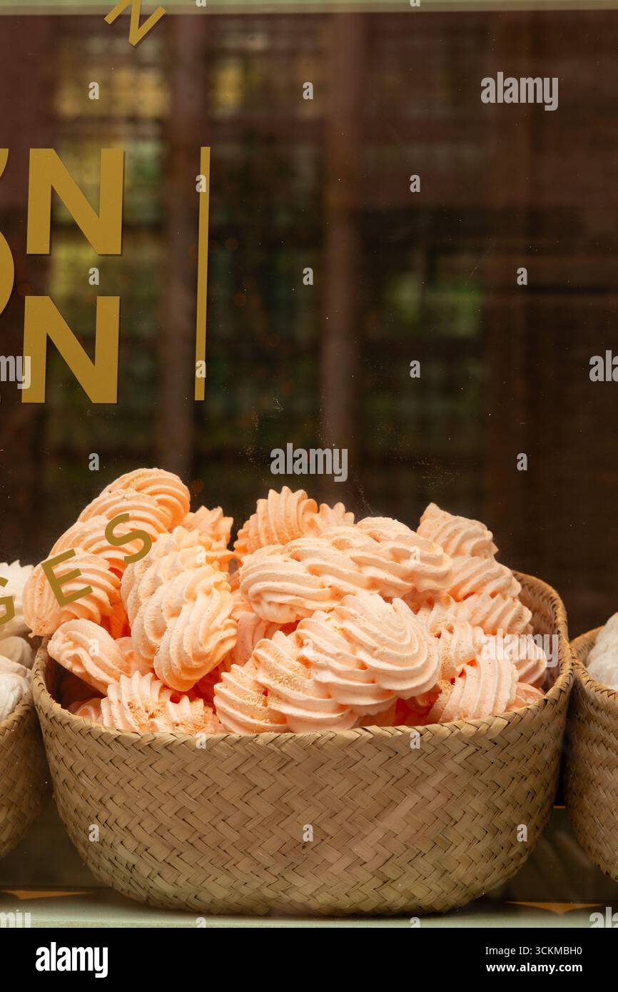 28 août 2025, Bruges, Belgique — tourbillons de guimauve orange vif disposés dans un panier en osier dans un magasin. Banque D'Images