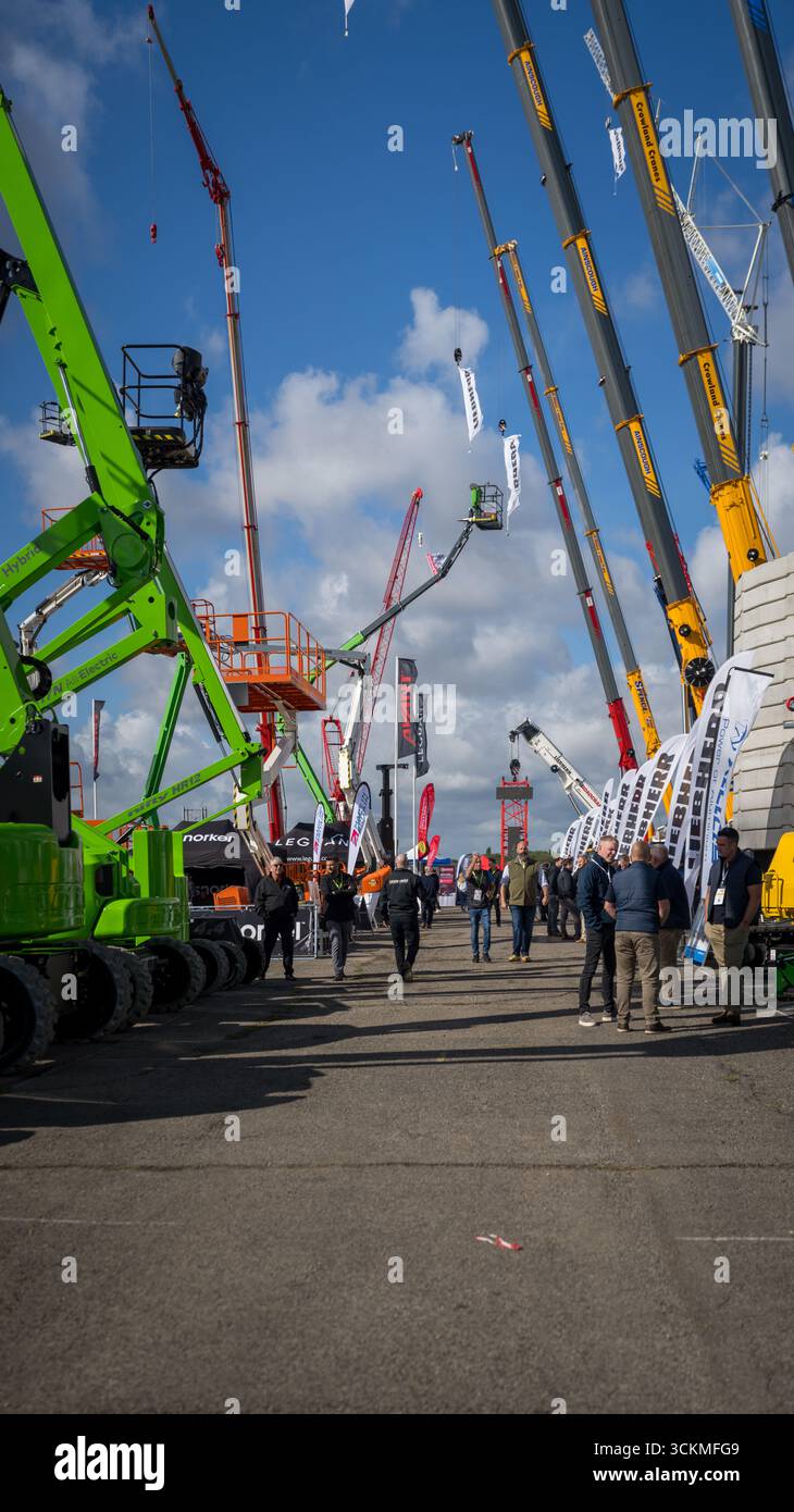 Entreprise de construction et ingénieurs visitant une exposition de plates-formes élévatrices et de machines pour la construction de bâtiments Banque D'Images