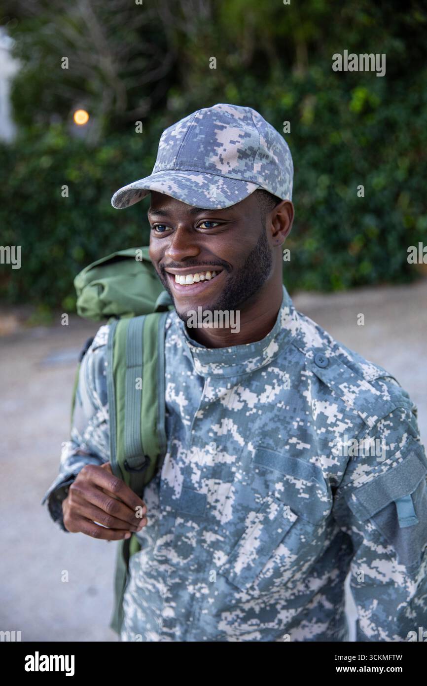 Soldat afro-américain debout sur la cour de la base portant un uniforme de camouflage, sac à dos Banque D'Images