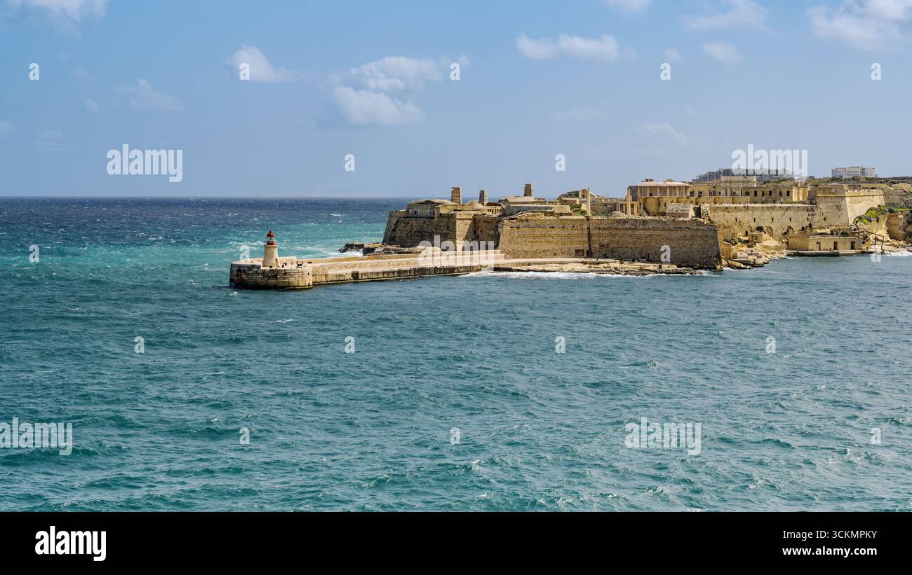 Vue sur Fort Ricasoli et le phare East Breakwater à l'entrée du Grand Port à la Valette, Malte. Banque D'Images
