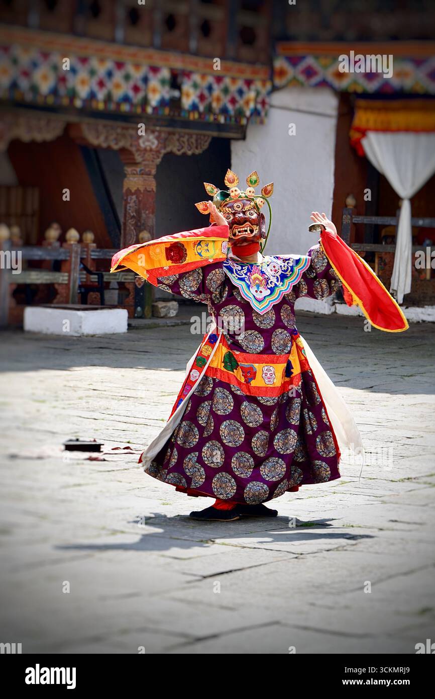 Danseuse masquée traditionnelle jouant lors d'un festival culturel au Bhoutan, vêtue d'un costume et d'un masque élaborés dans le cadre d'un rituel sacré de danse Cham Banque D'Images