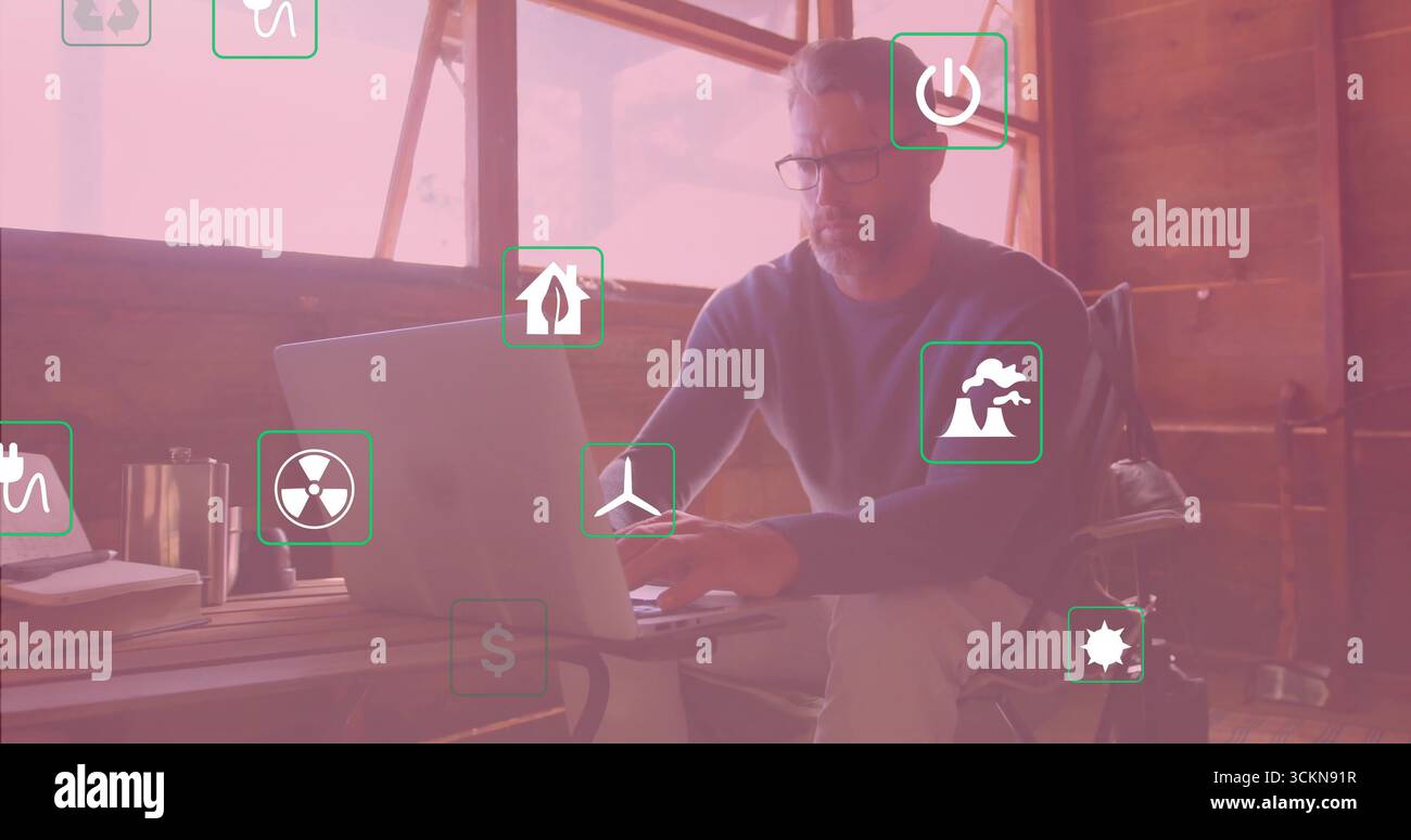 Homme mature travaillant tapant sur ordinateur portable dans le bureau rustique, avec des icônes de tasse et d'énergie, espace de copie Banque D'Images