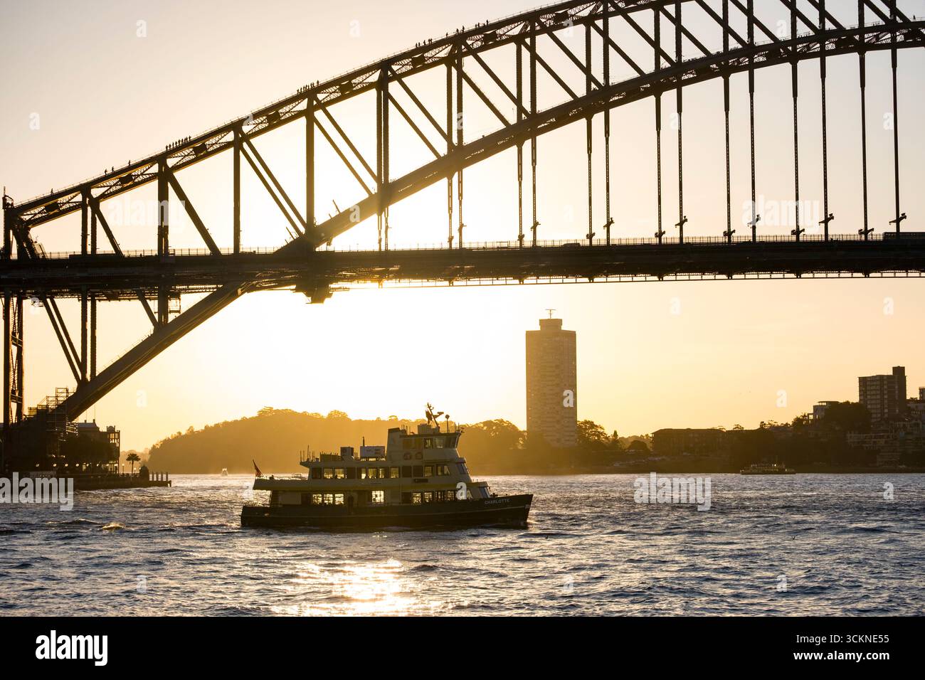 Une silhouette pittoresque du Sydney Harbour Bridge avec une traversée en ferry au coucher du soleil, mettant en valeur l'harmonie urbaine et côtière, Sydney Harbour, Sydney, N. Banque D'Images