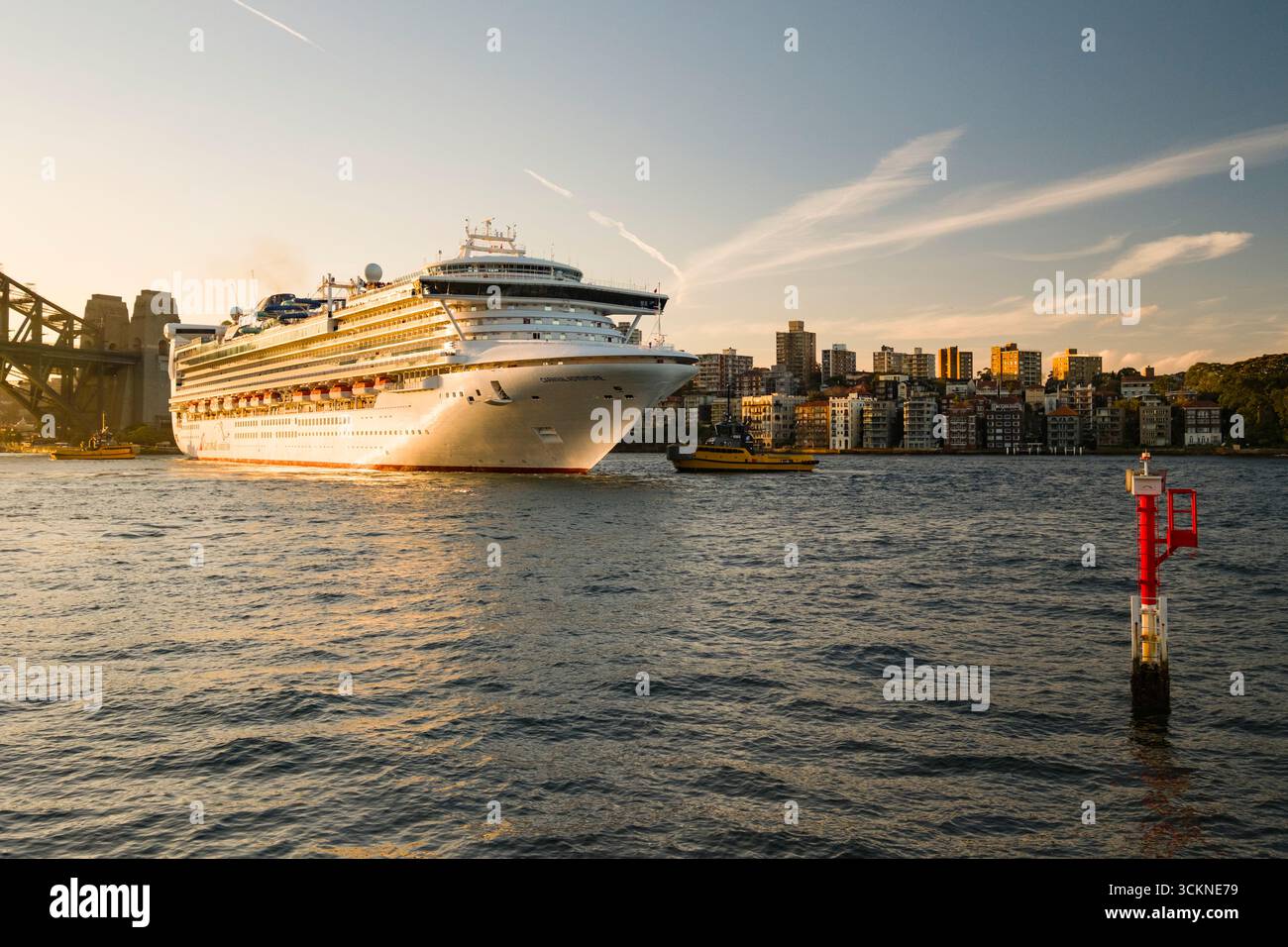 Un grand bateau de croisière dans le port de Sydney près d'une ville au coucher du soleil, mettant en valeur l'architecture urbaine, le tourisme aquatique et les expériences de voyage pittoresques, Sydney, ne Banque D'Images