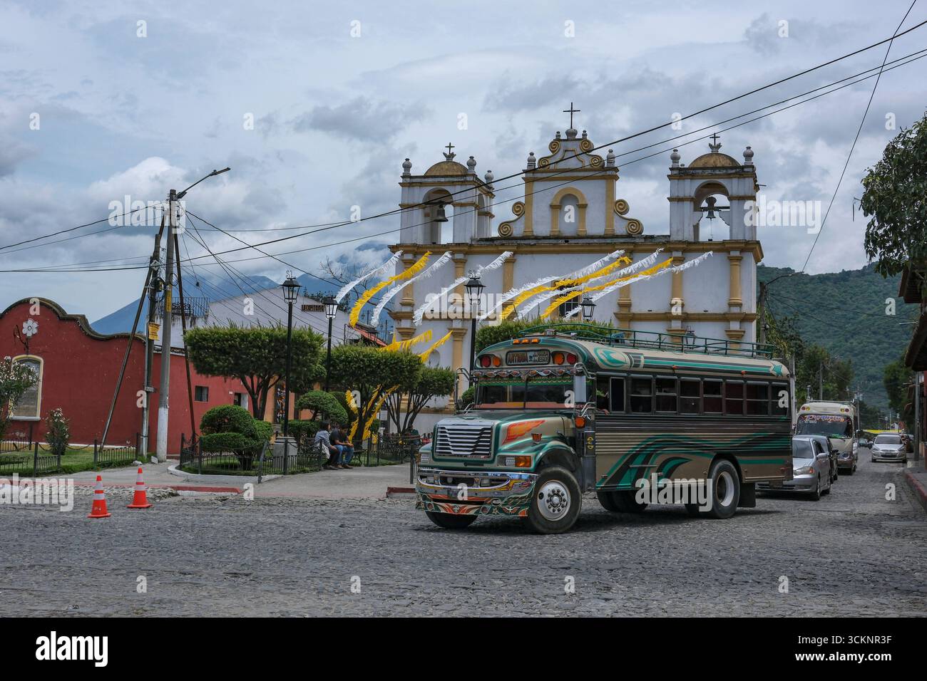 Antigua Guatemala, Guatemala - 25 juin 2025 : bus de poulet, un bus de passagers typique d'Amérique centrale, passant par l'Ermitage de Santa Lucia. Banque D'Images