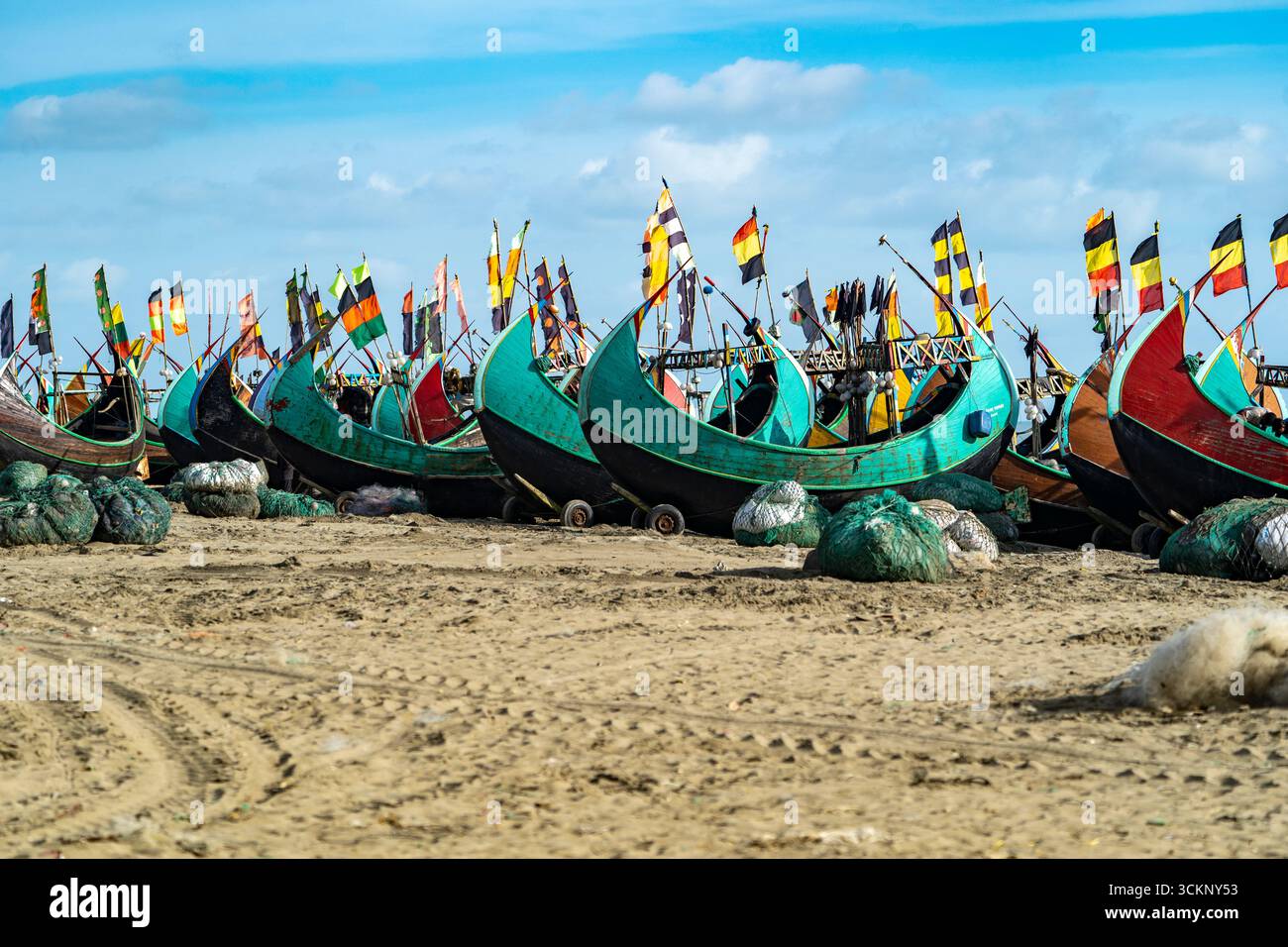 Rangée de bateaux de pêche sur Sandy Beach à Teknaf Sea Beach. Bateau de pêche en bois coloré sur une plage de mer de Cox's Bazar, Bangladesh avec fond de ciel bleu. Banque D'Images
