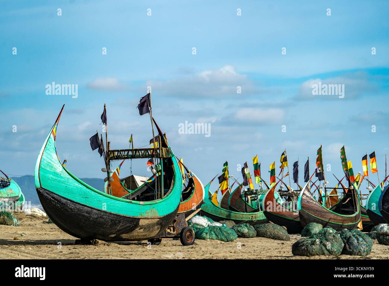 Rangée de bateaux de pêche sur Sandy Beach à Teknaf Sea Beach. Bateau de pêche en bois coloré sur une plage de mer de Cox's Bazar, Bangladesh avec fond de ciel bleu. Banque D'Images