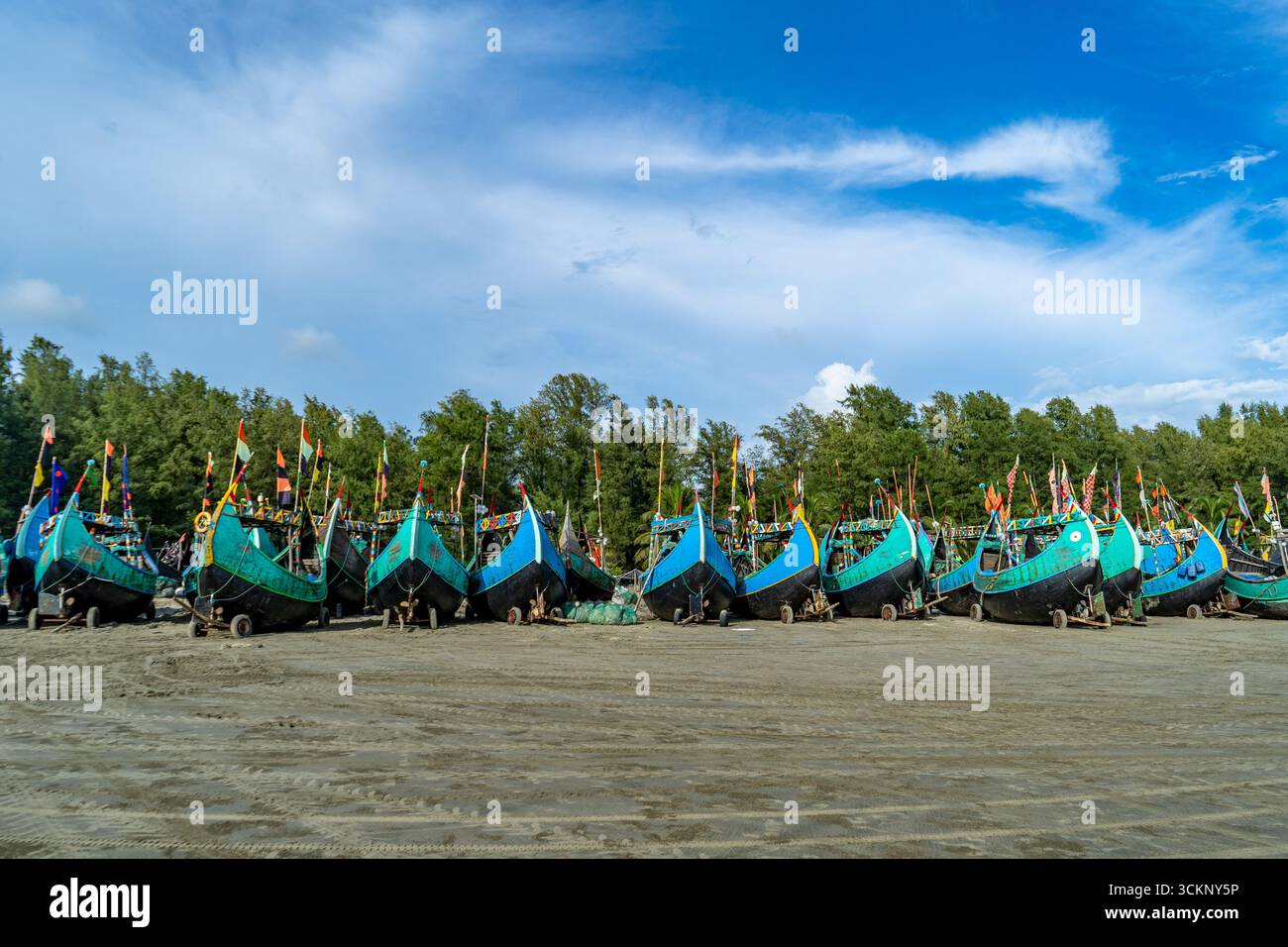 Rangée de bateaux de pêche sur Sandy Beach à Teknaf Sea Beach. Bateau de pêche en bois coloré sur une plage de mer de Cox's Bazar, Bangladesh avec fond de ciel bleu. Banque D'Images