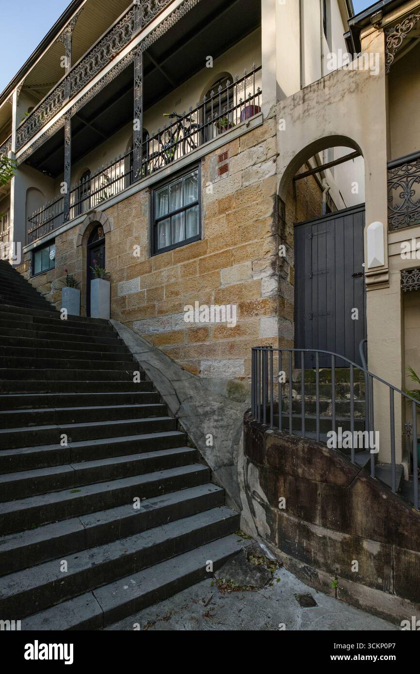 Scène urbaine historique avec un escalier en pierre adjacent à un mur rustique et des détails de balcon, mettant en valeur le charme architectural, Sydney Banque D'Images Scène urbaine historique avec un escalier en pierre adjacent à un mur rustique et des détails de balcon, mettant en valeur le charme architectural, Sydney Banque D'Images