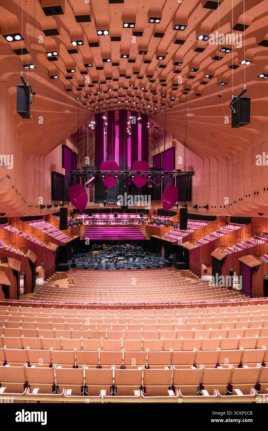 Superbe vue intérieure de la salle de concert de l'Opéra de Sydney avec rangées de sièges, couleurs éclatantes et mise en scène. La conception architecturale souligne Banque D'Images