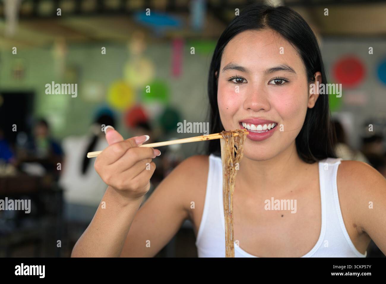 Belle jeune femme thaïlandaise mangeant les célèbres nouilles de bateau de nourriture de rue de Thaïlande servies au restaurant local Banque D'Images