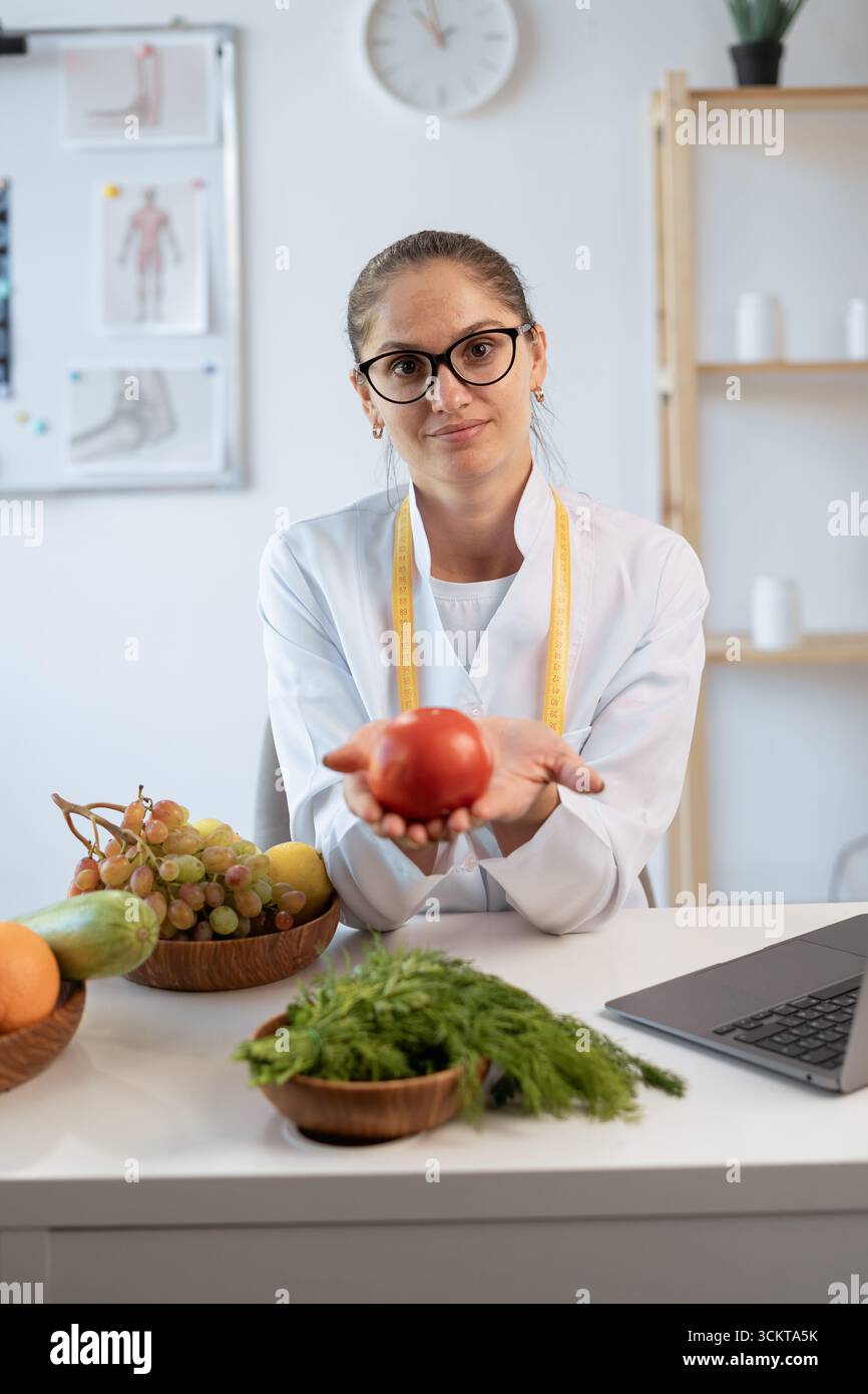 Concept de nourriture saine, bonne nutrition et régime alimentaire. Jeune nutritionniste caucasien donnant consultation au patient avec des aliments sains comme fruits et végétabl Banque D'Images