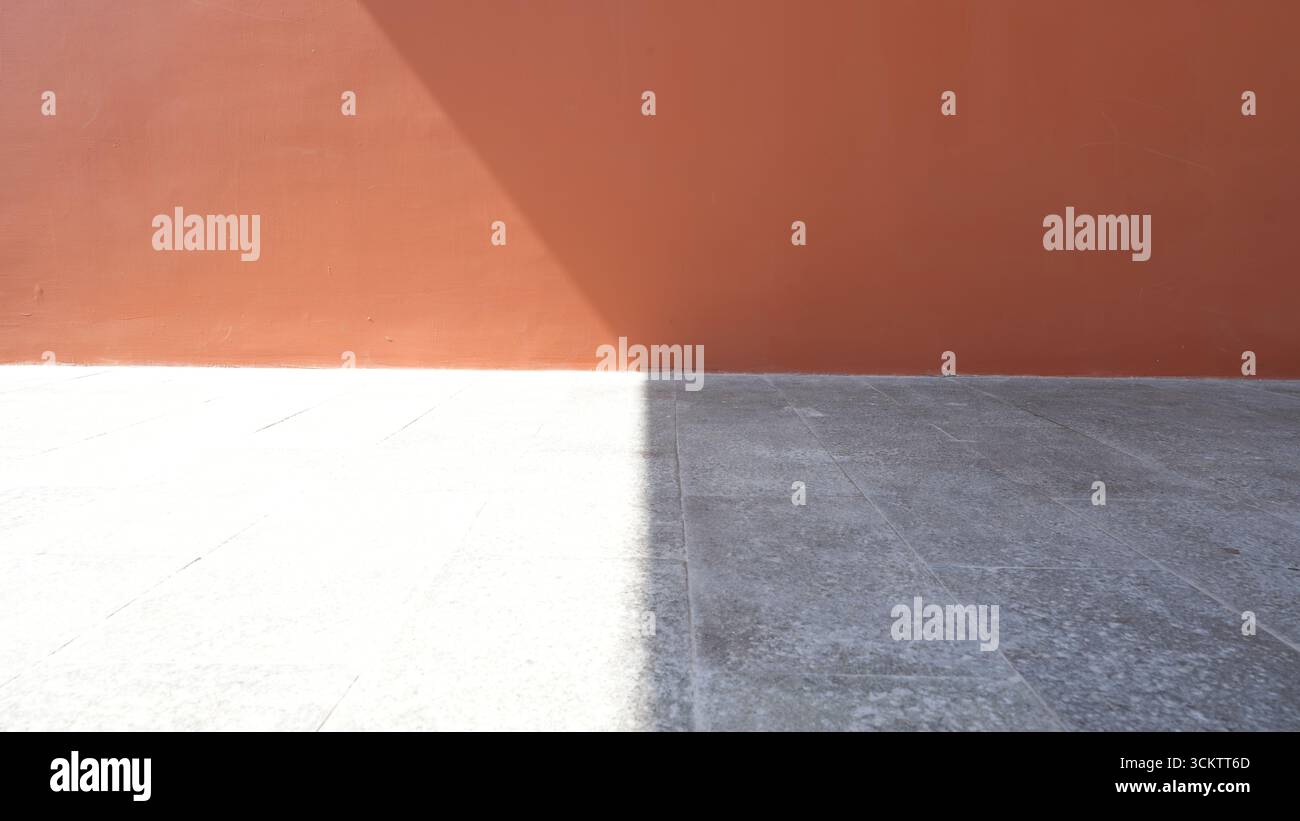 Ombre portée organique, diagonale sur un mur orange et texture de tuile grise, effet de superposition pour la photo. Effet de texture léger. Banque D'Images