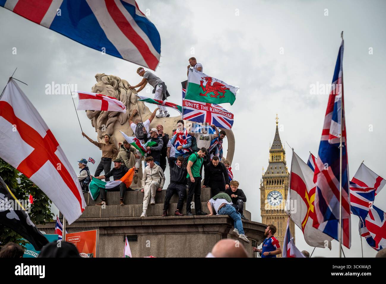 Manifestants sur l'un des lions sur le pont de Westminster, la marche « Unite the Kingdom » menée par Tommy Robinson rassemble des centaines de milliers de manifestants en cent Banque D'Images