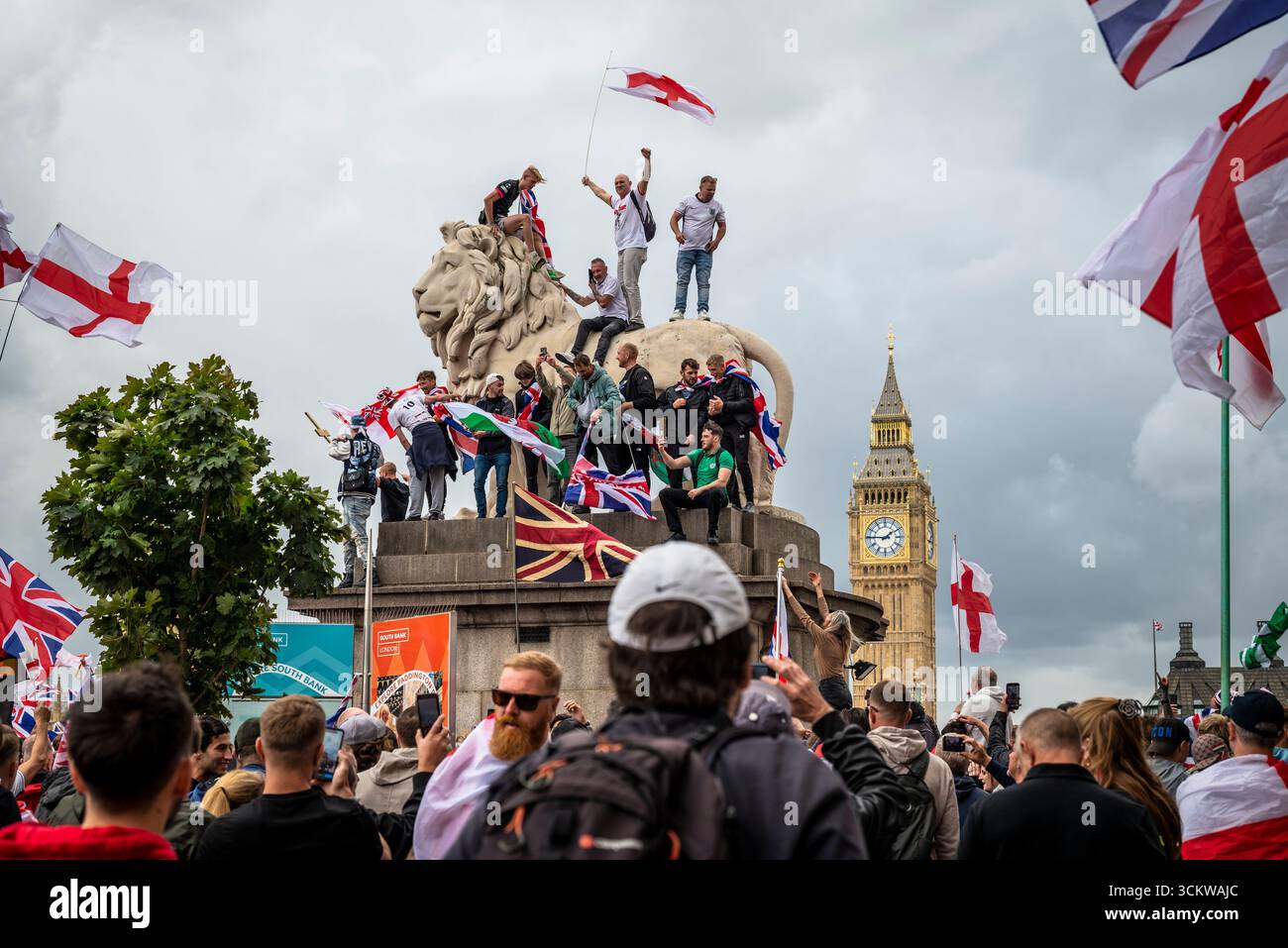 Manifestants sur l'un des lions sur le pont de Westminster, la marche « Unite the Kingdom » menée par Tommy Robinson rassemble des centaines de milliers de manifestants en cent Banque D'Images